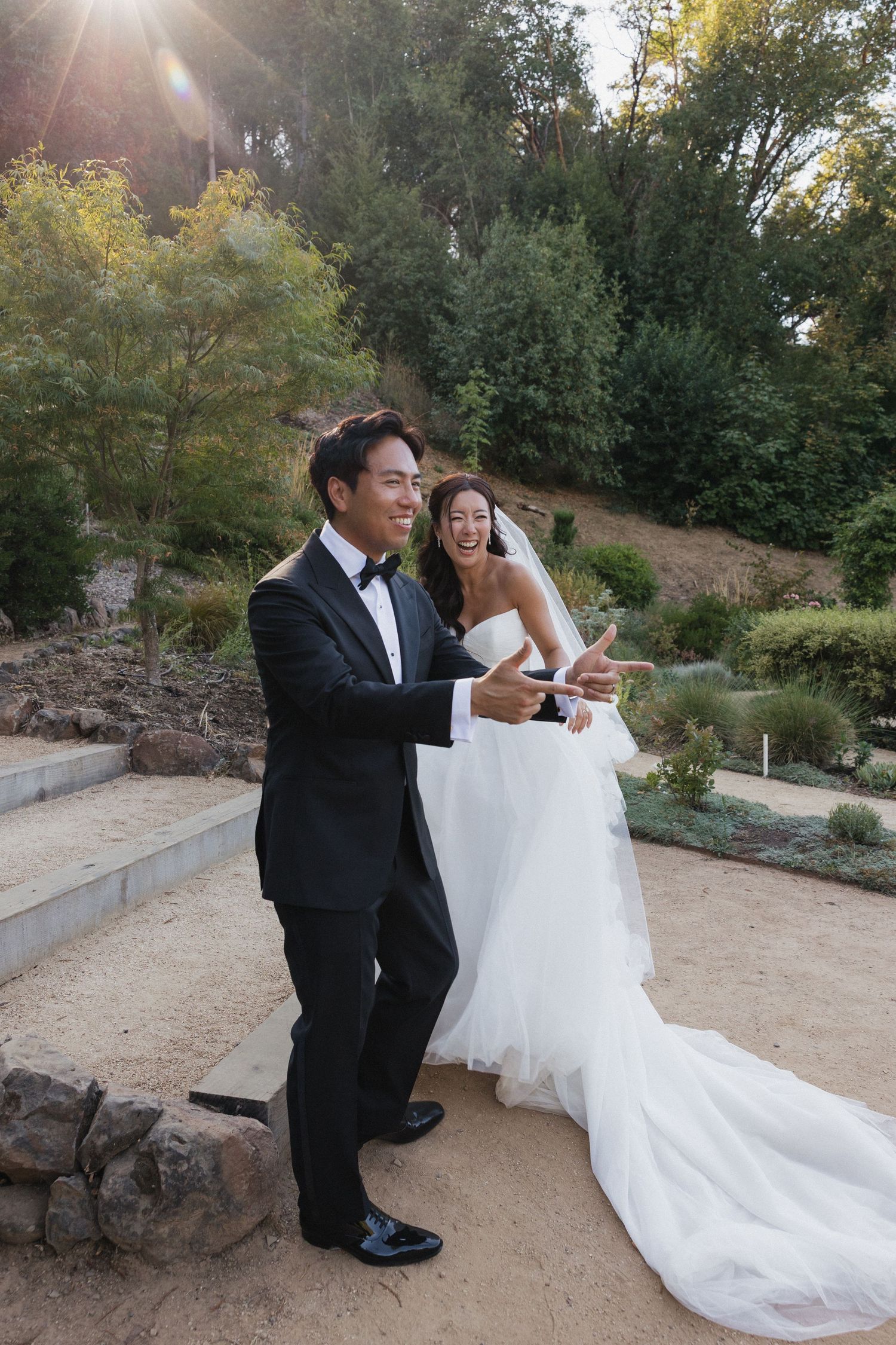 A couple shares a playful moment during their wedding photoshoot in golden sunset light.