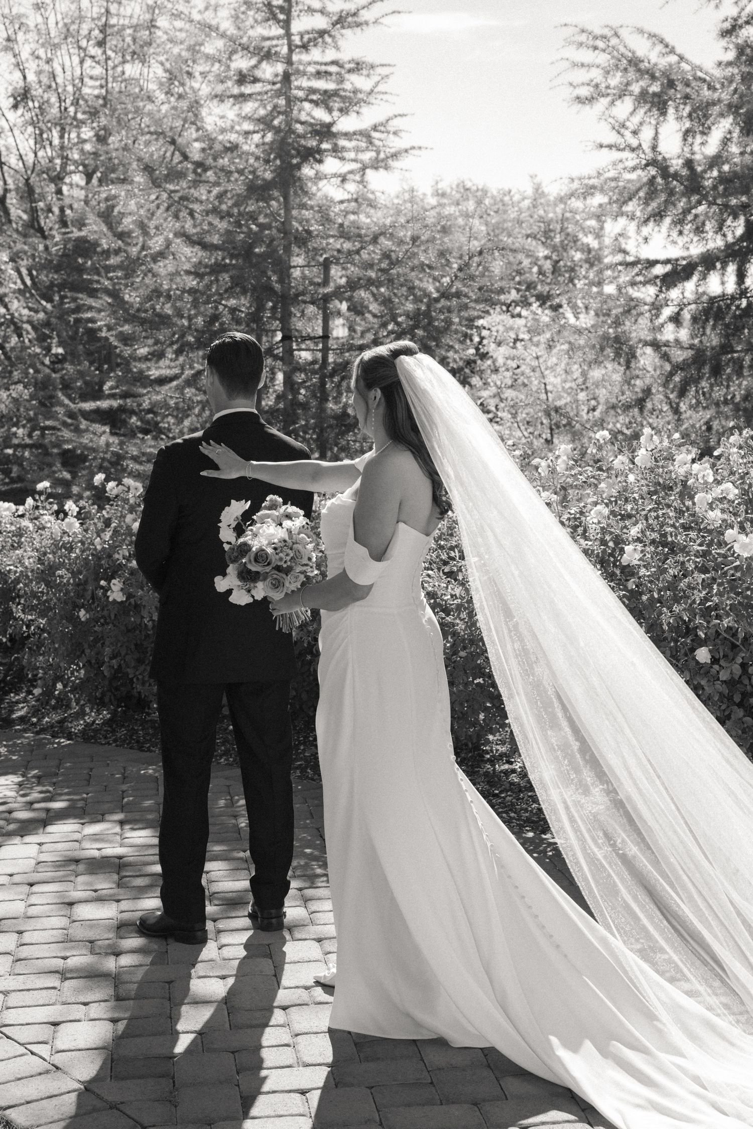 Sequence of black and white photos showing a couple dancing on a stone patio with flowing wedding dress.