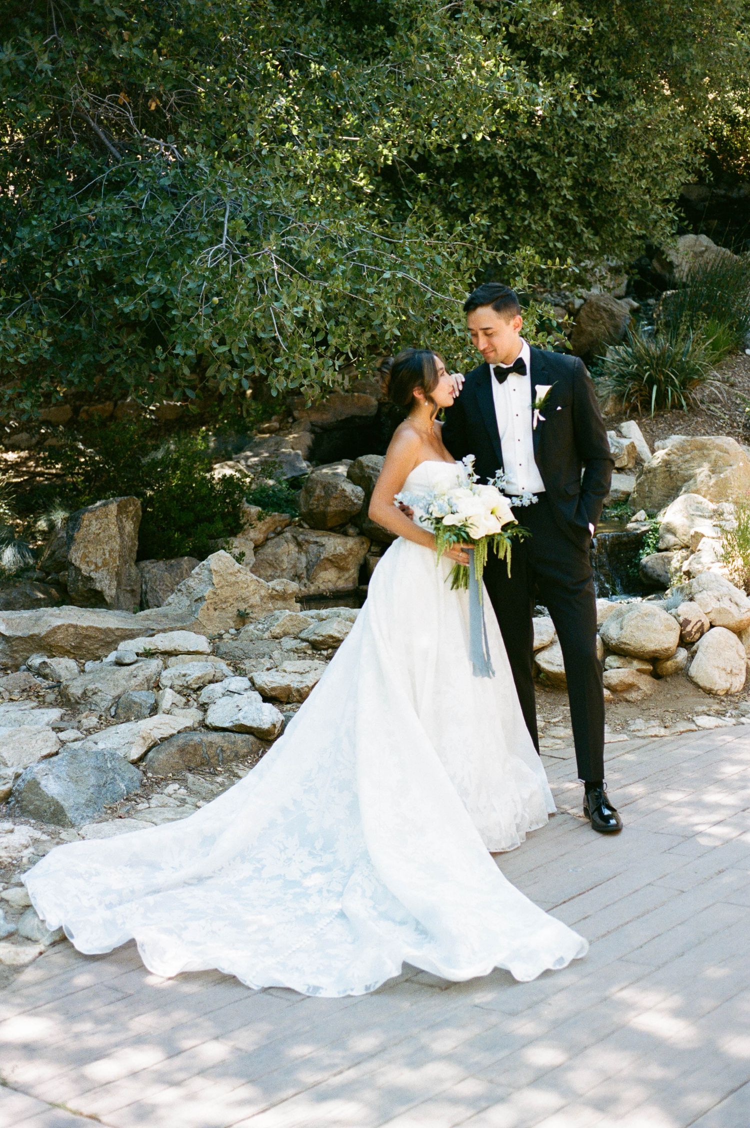 Outdoor wedding photo sequence featuring a bride in a dramatic white gown with flowing train against a rocky backdrop.