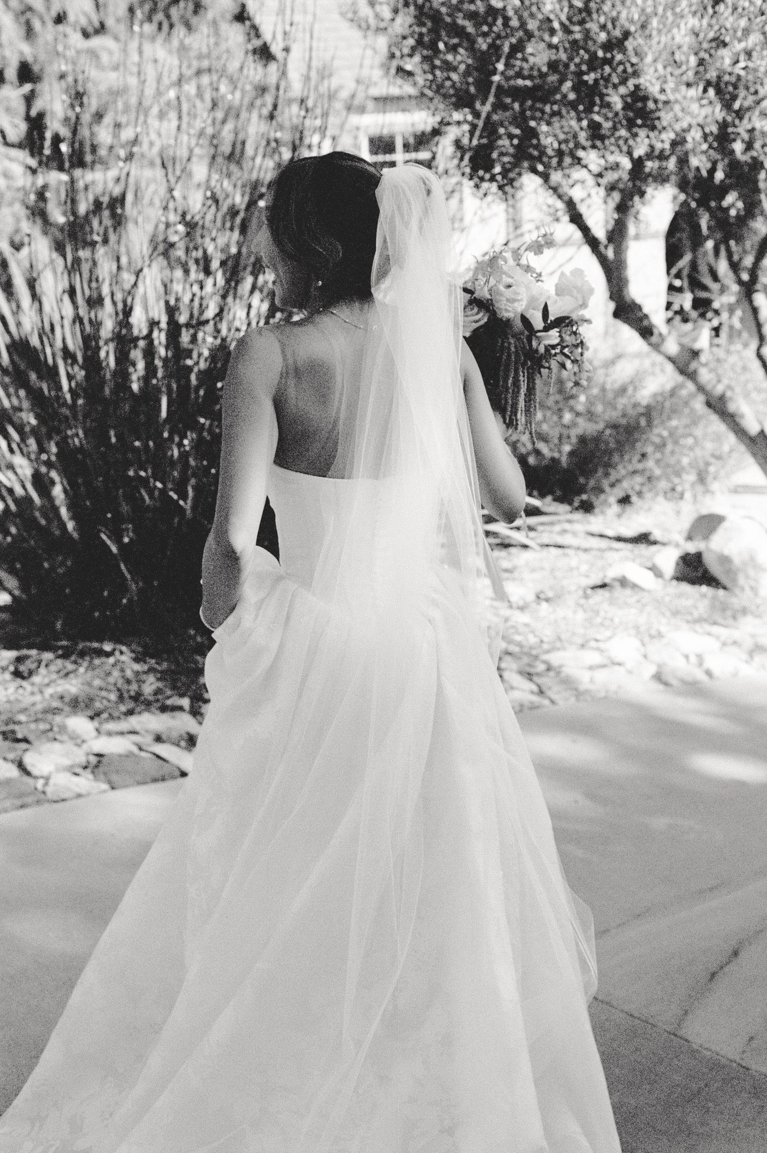 Black and white photo series showing the elegant sweep of a flowing white wedding dress train in outdoor setting.