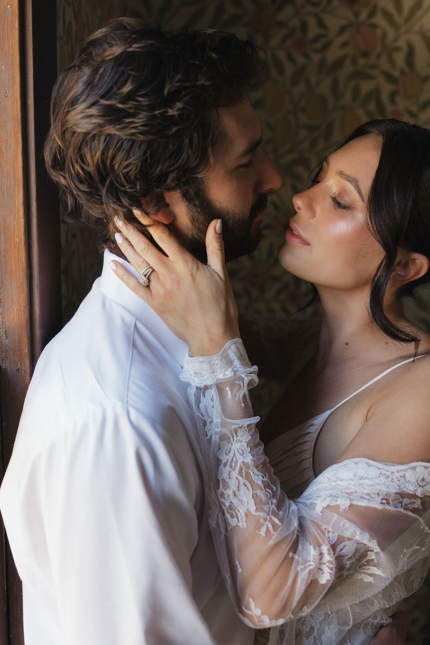A romantic sequence of wedding photos showing a couple in white attire sharing an intimate moment against a textured wall.