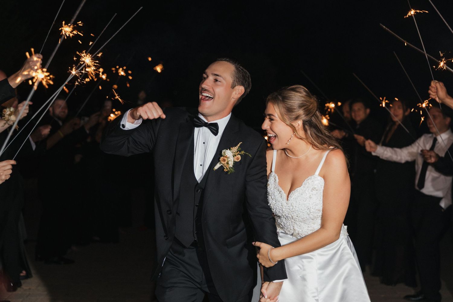 Nighttime wedding celebration with sparklers creating a magical atmosphere.
