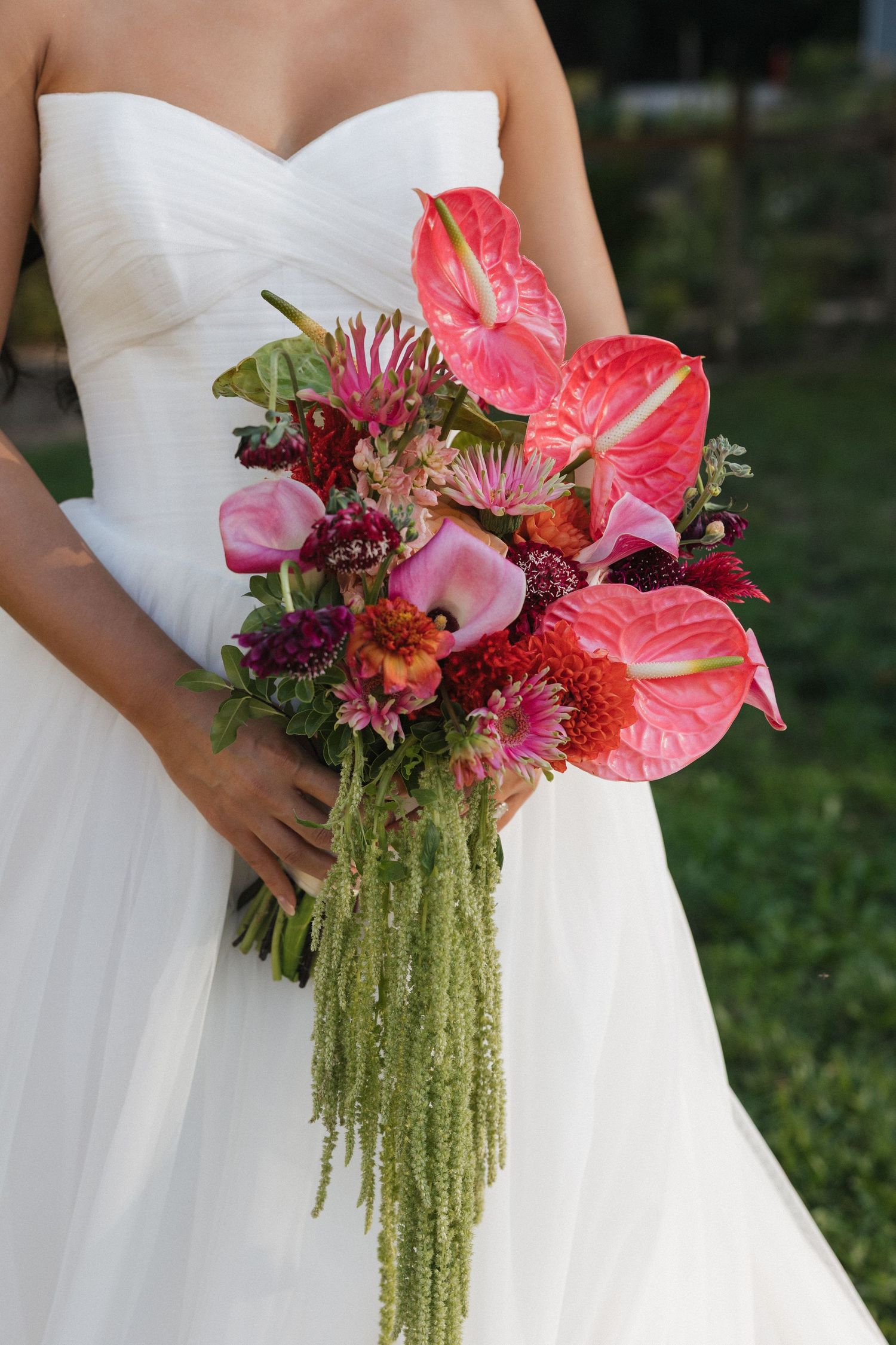 Stunning tropical bouquet with pink anthurium flowers and cascading green amaranthus.