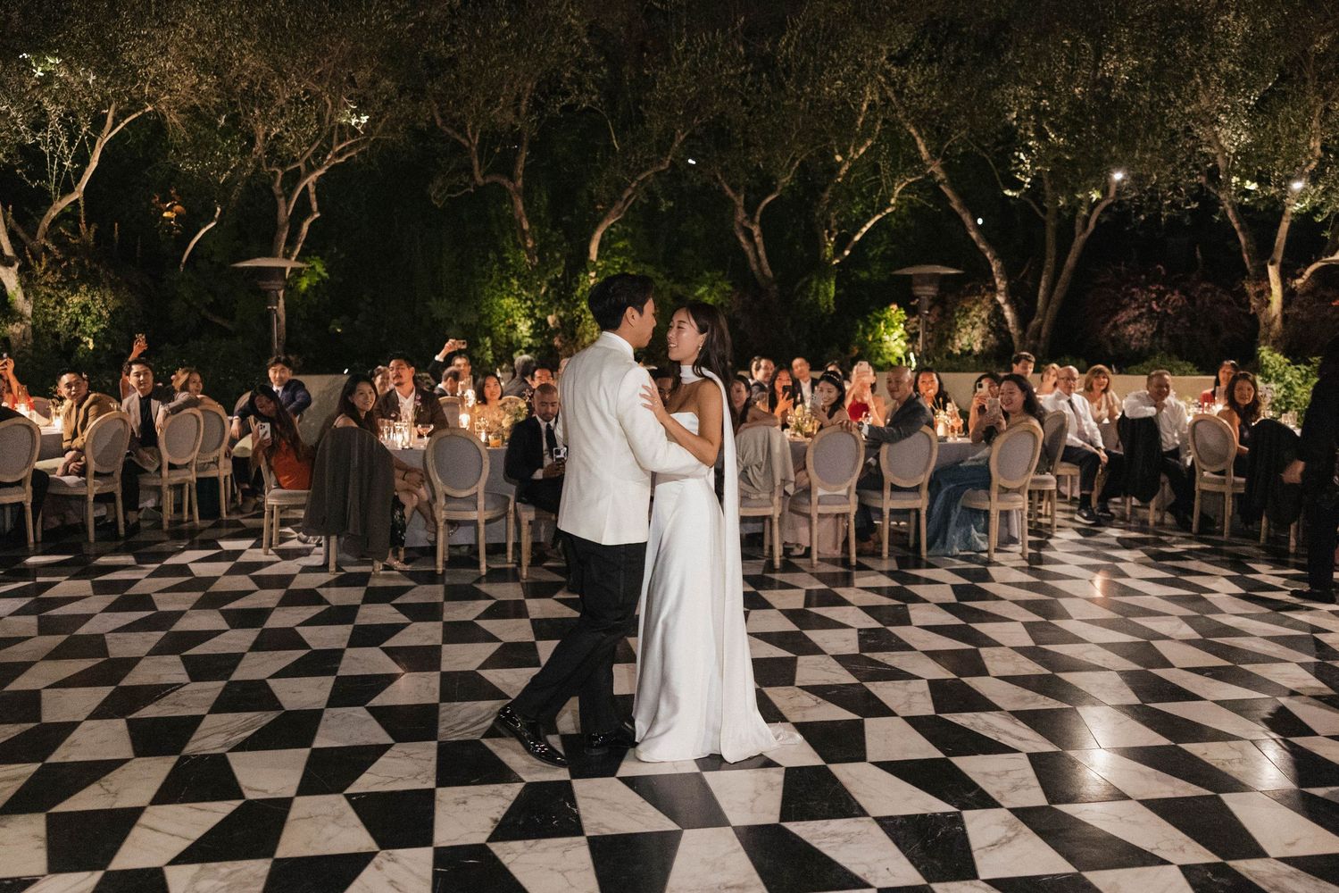 Outdoor wedding reception with black and white checkered dance floor.