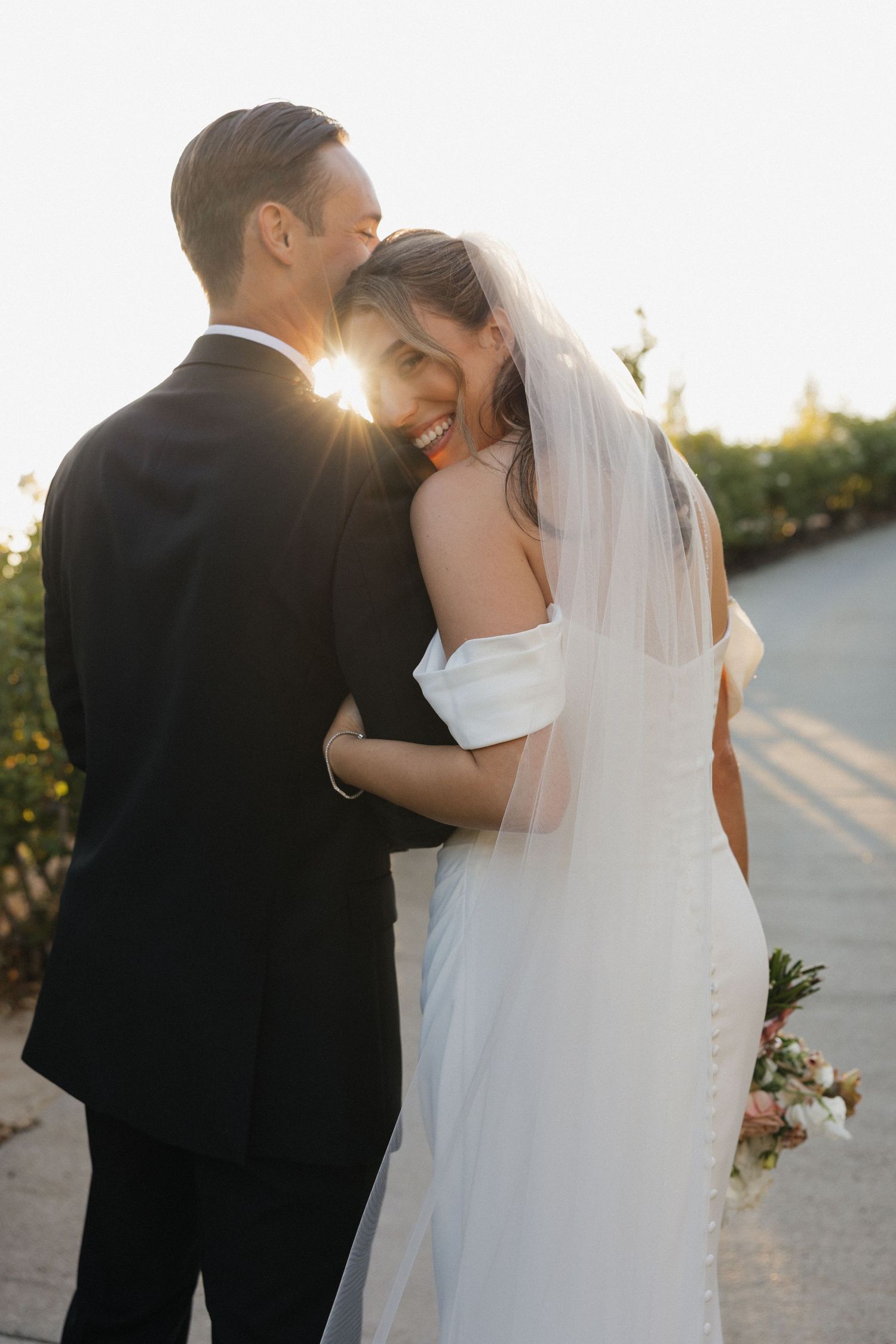Romantic sunset wedding photos with couple embracing in formal attire.
