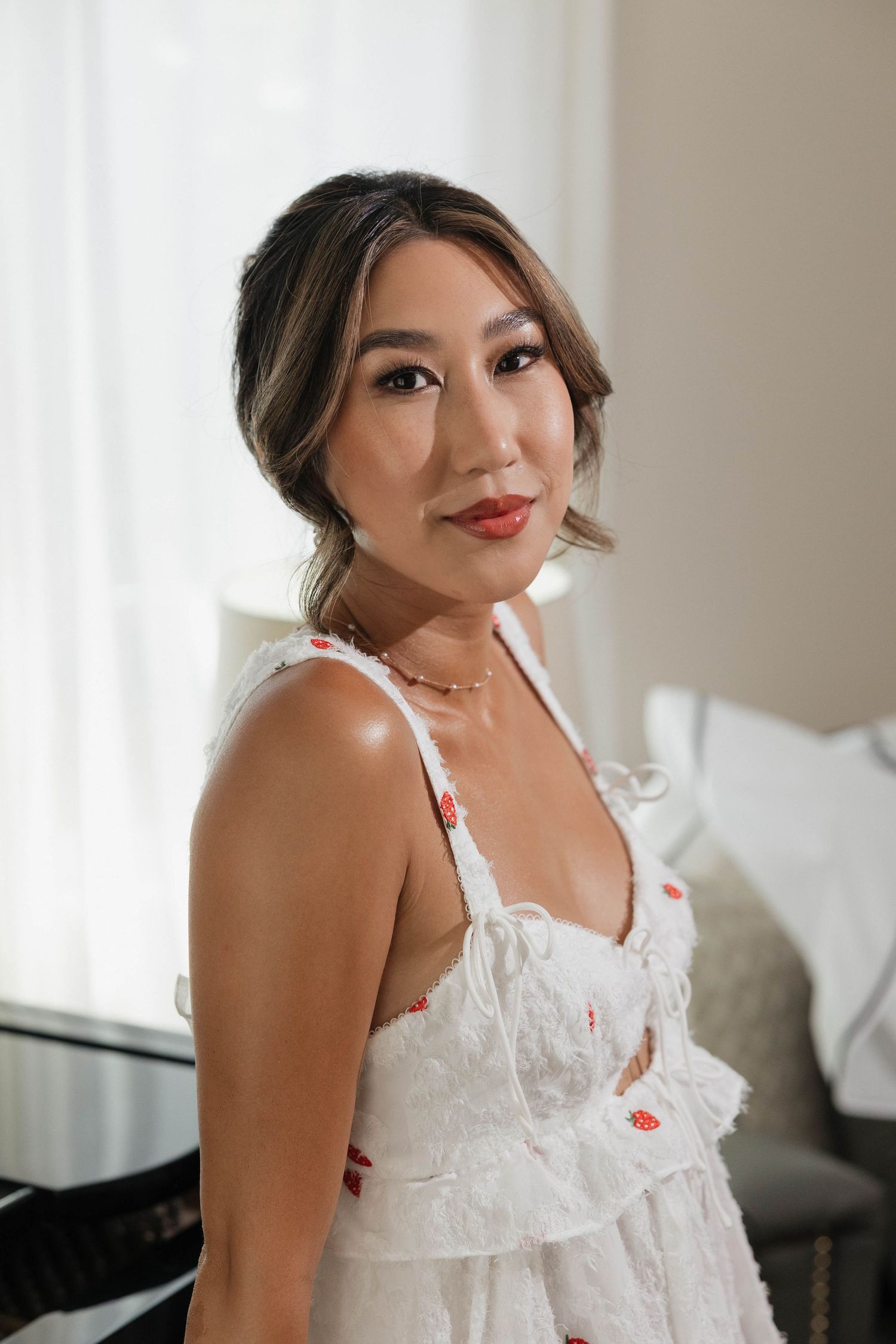 A bride wearing a delicate white lace lingerie piece during wedding preparations.