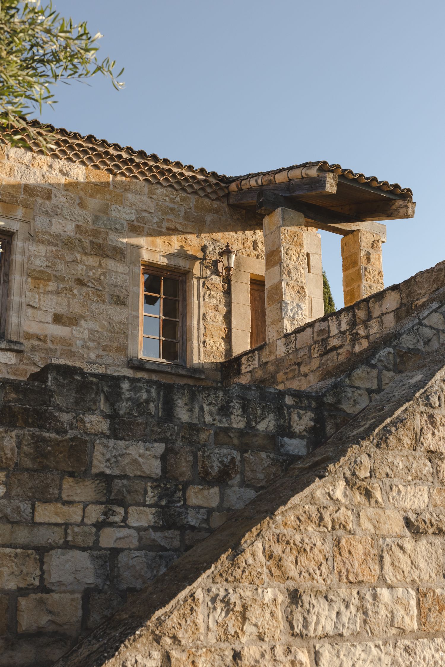 Stone architecture with terracotta roof tiles and multiple levels showcases Mediterranean design.
