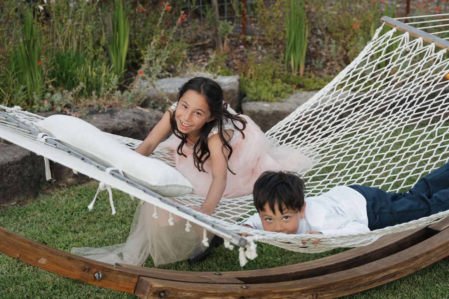 Couple relaxing in a hammock surrounded by garden greenery.