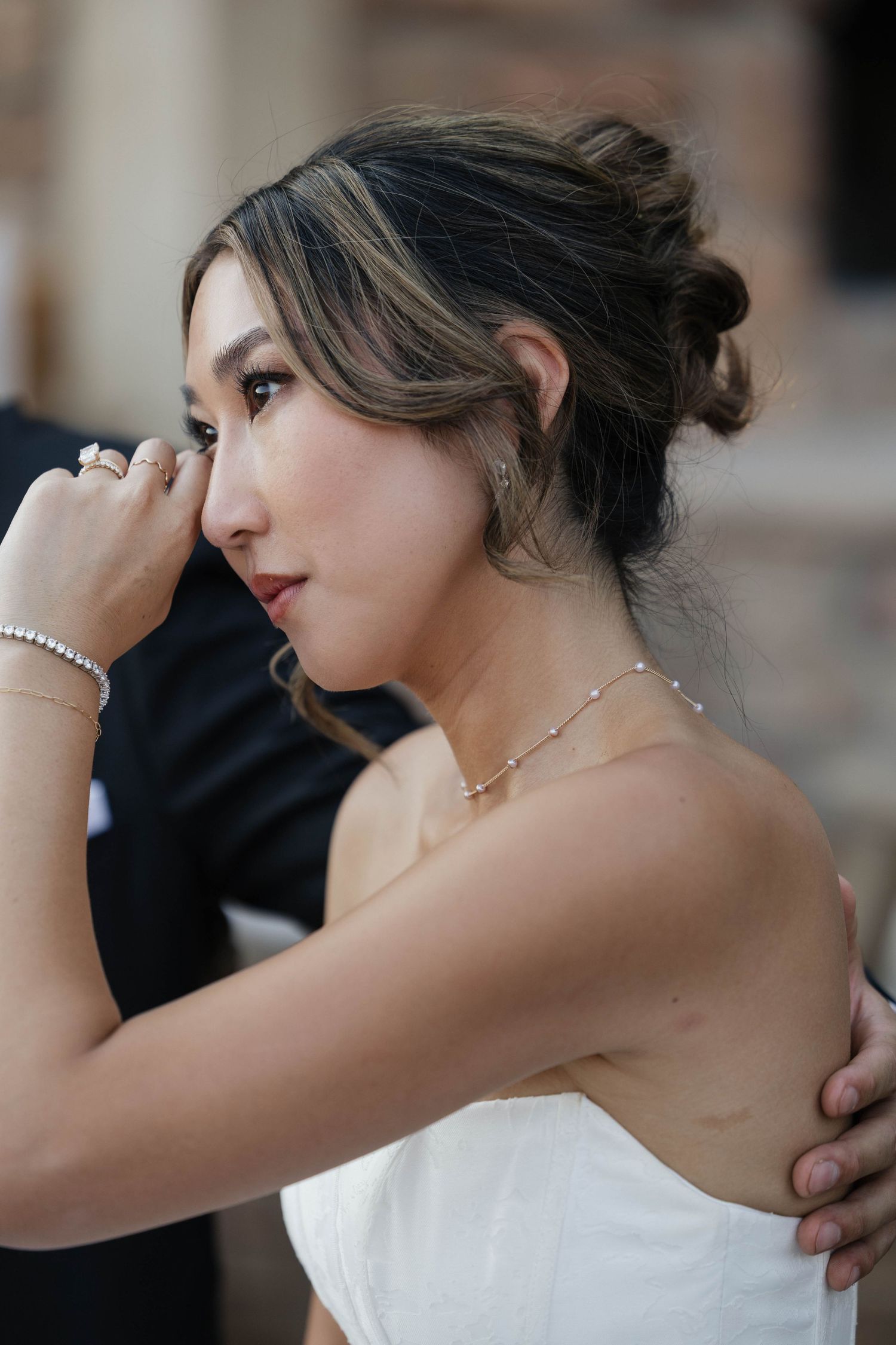 Elegant bride in strapless gown poses gracefully with upswept hair.