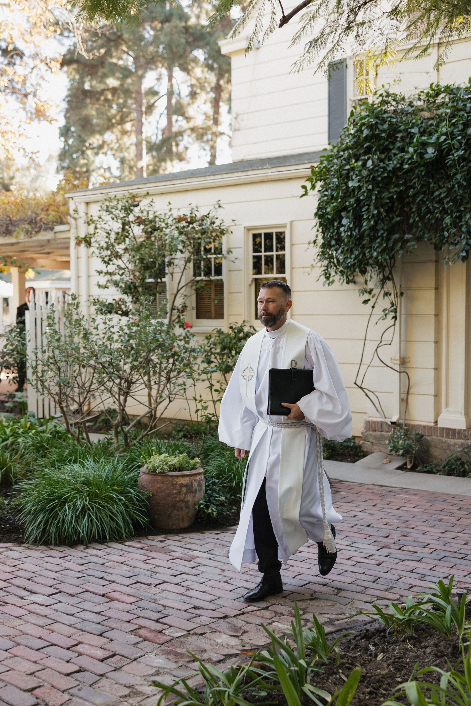 Staff in white uniforms prepare for service outside a stately white building.