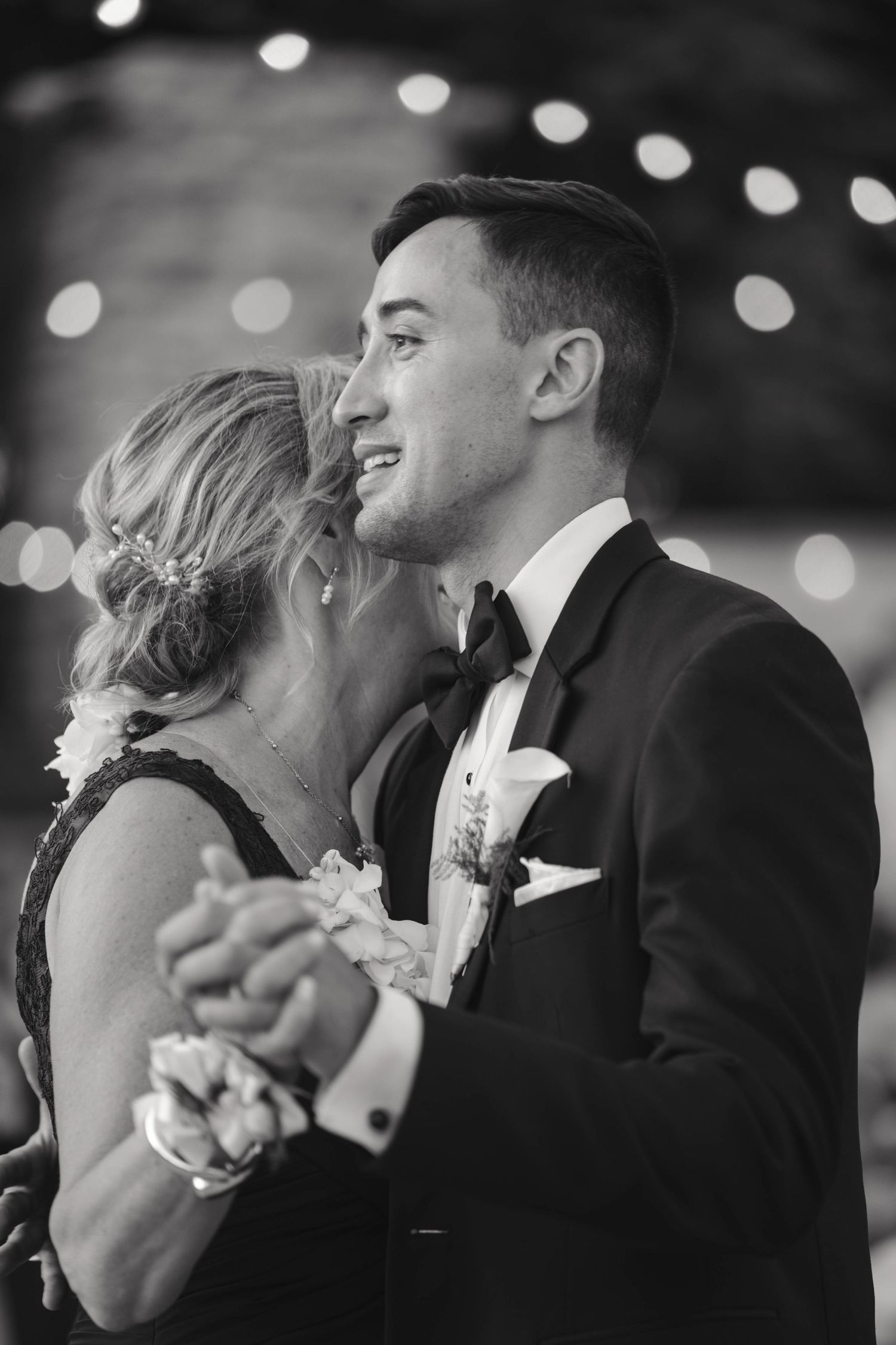Intimate black and white dance floor moment between couple at wedding reception.