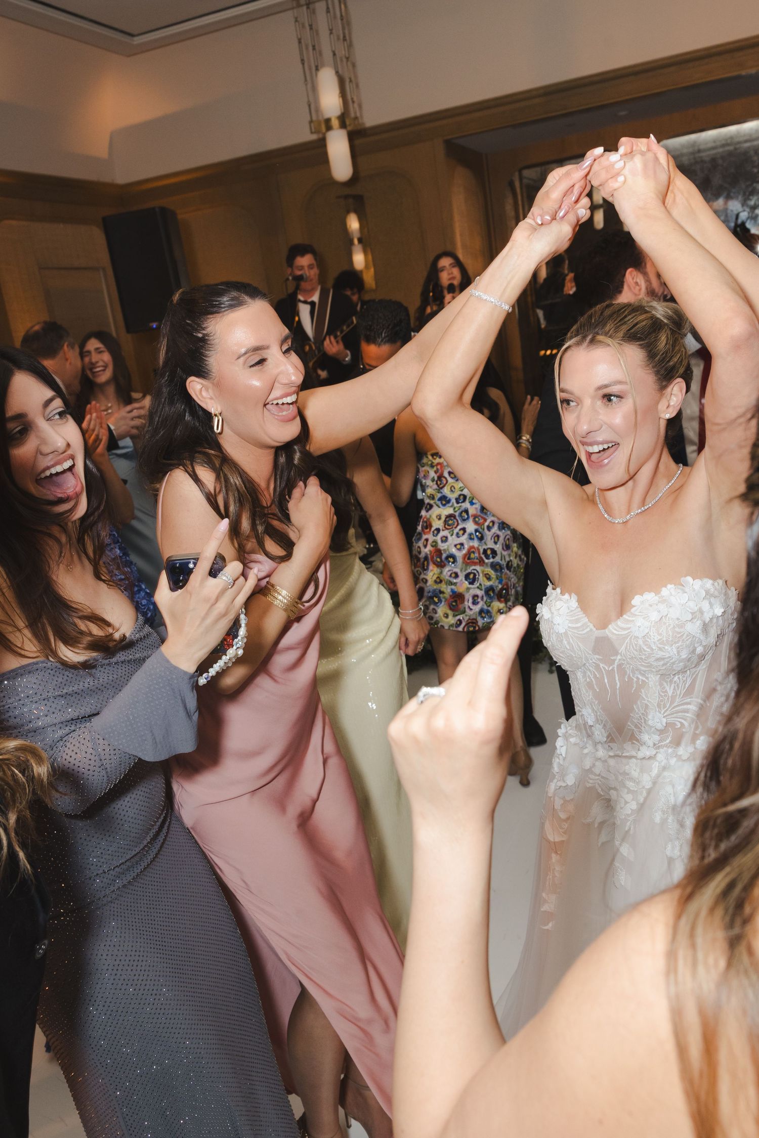 Wedding guests dancing and celebrating together joyfully at a reception party.