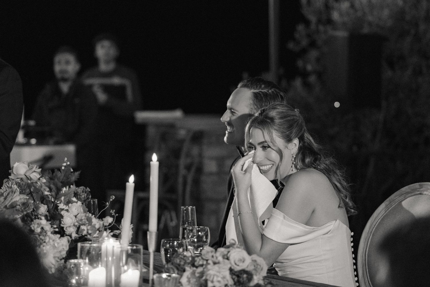 Black and white candlelit wedding reception scene.