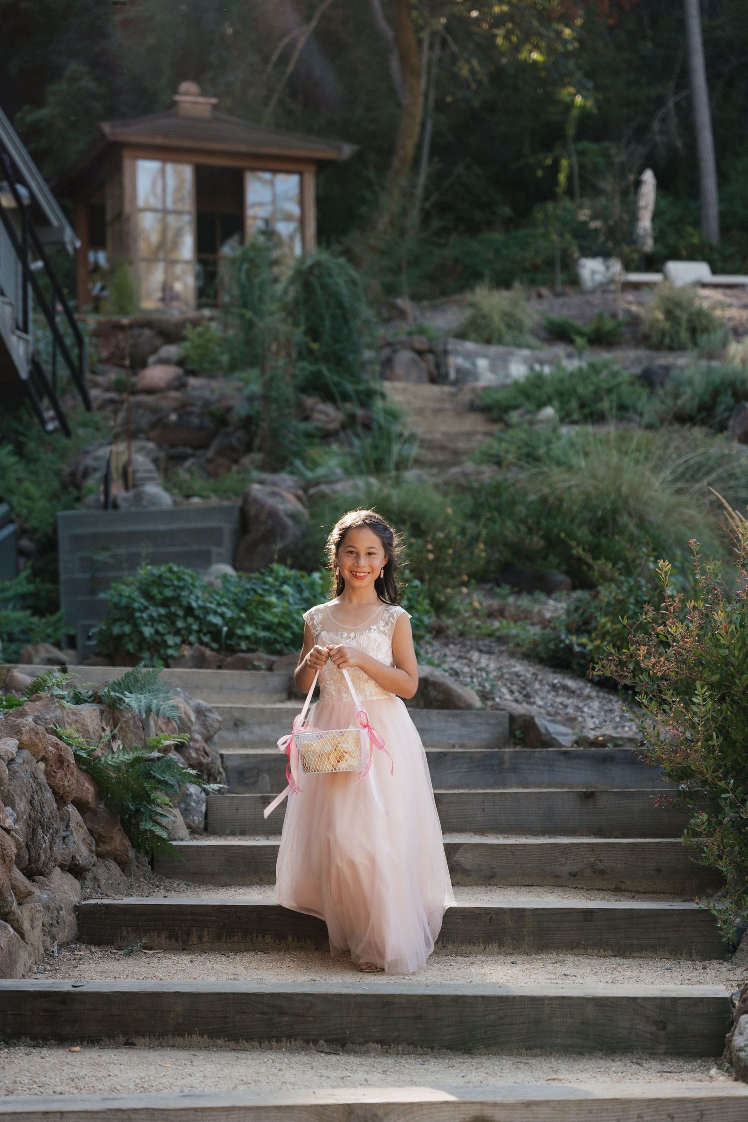 A person in a pink tulle dress sits gracefully on outdoor stone steps.