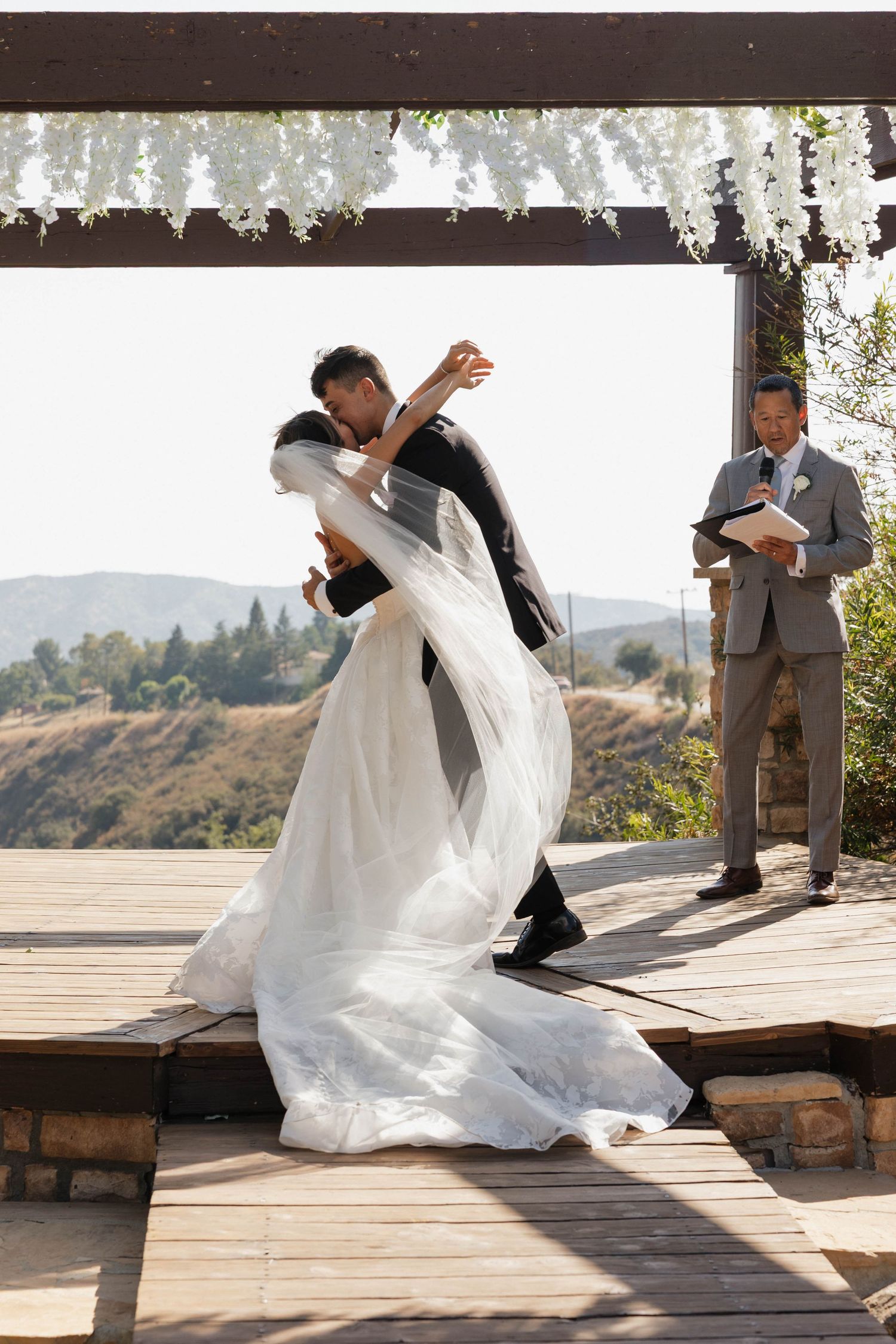 Dramatic dip during first dance at outdoor mountain wedding ceremony.