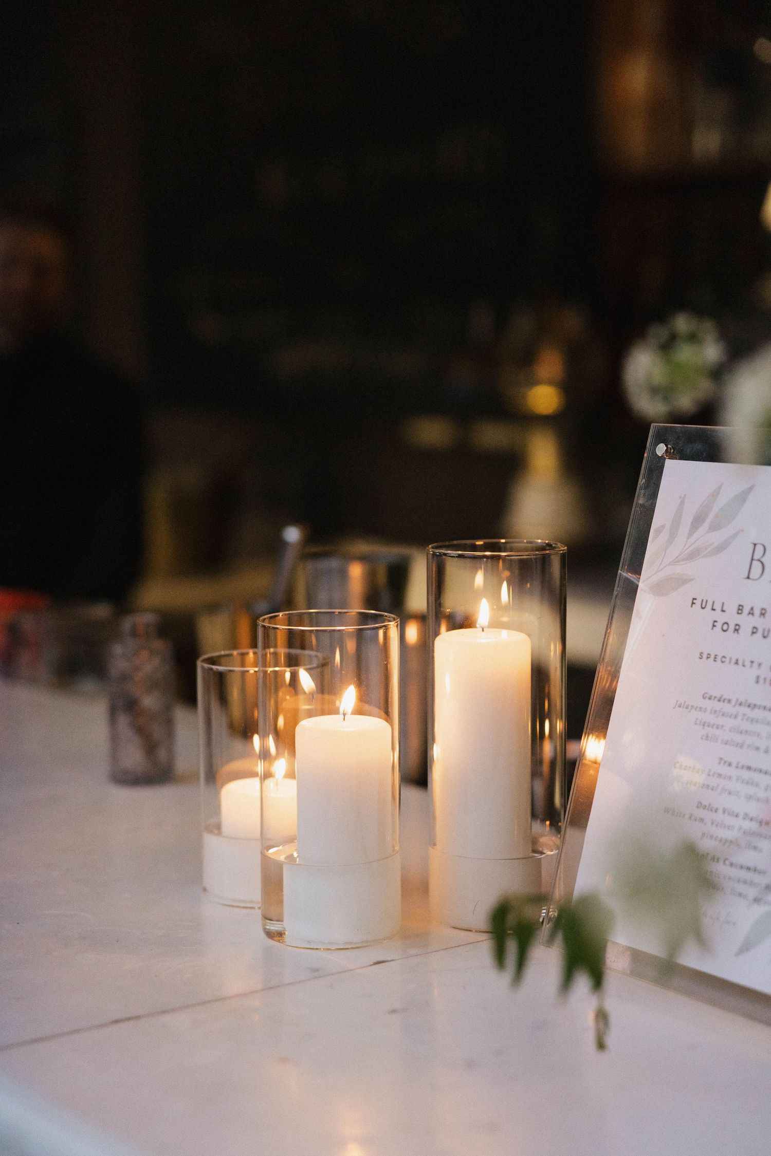 White candles and menu cards create an intimate atmosphere on elegant dining tables.