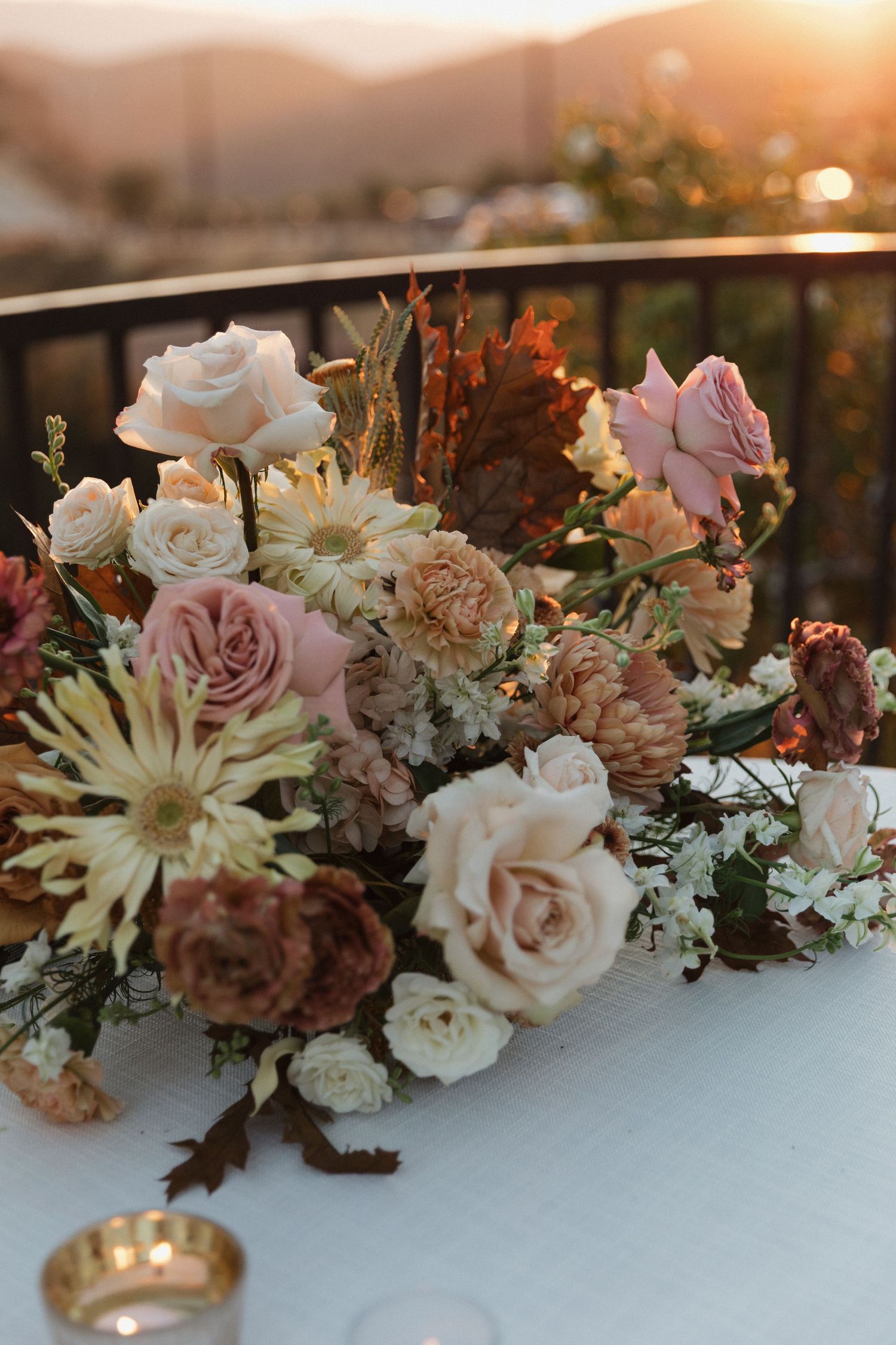 Elegant floral arrangement with roses and daisies in soft pink and white tones.
