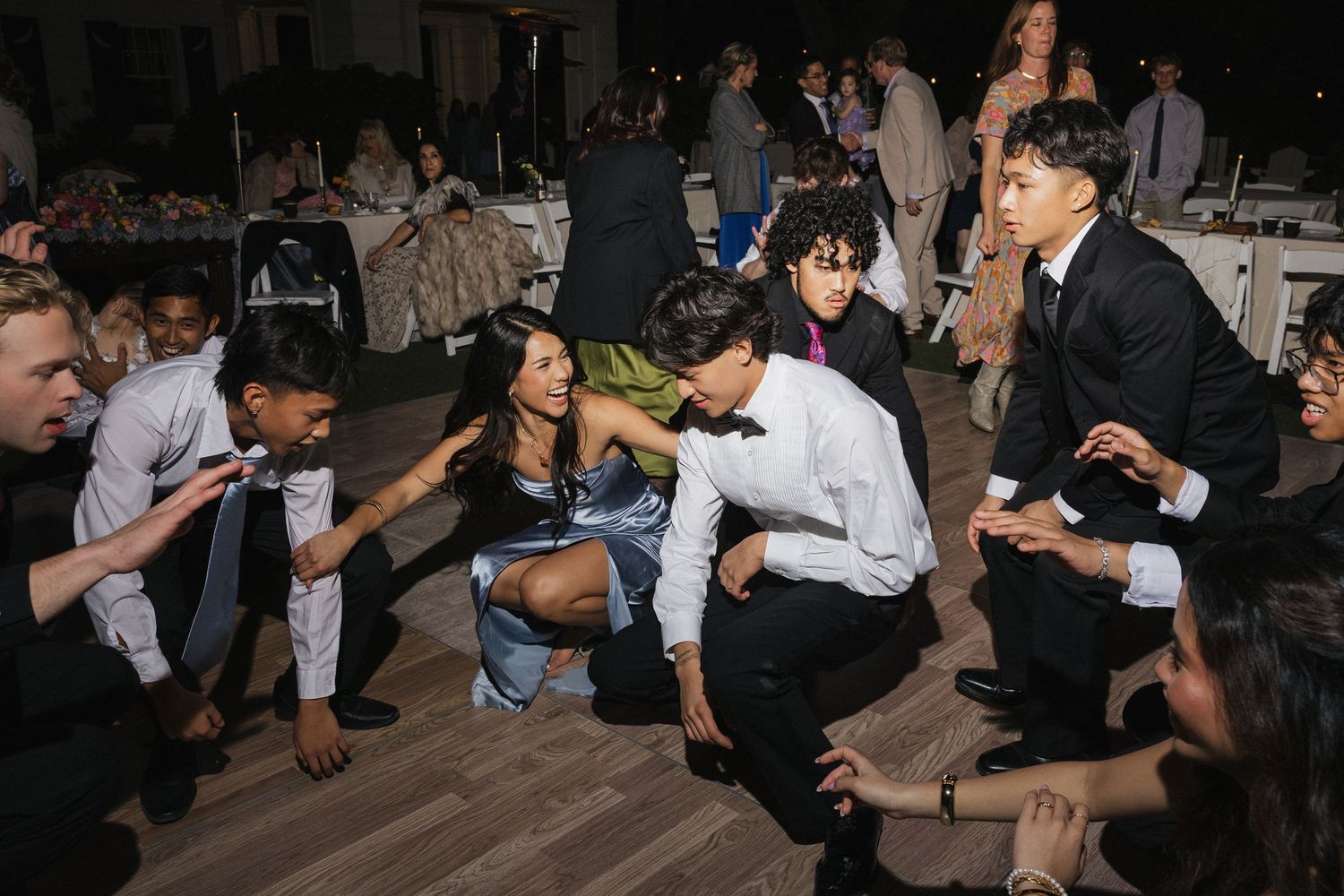 People dancing and socializing at a dimly lit indoor party or celebration.