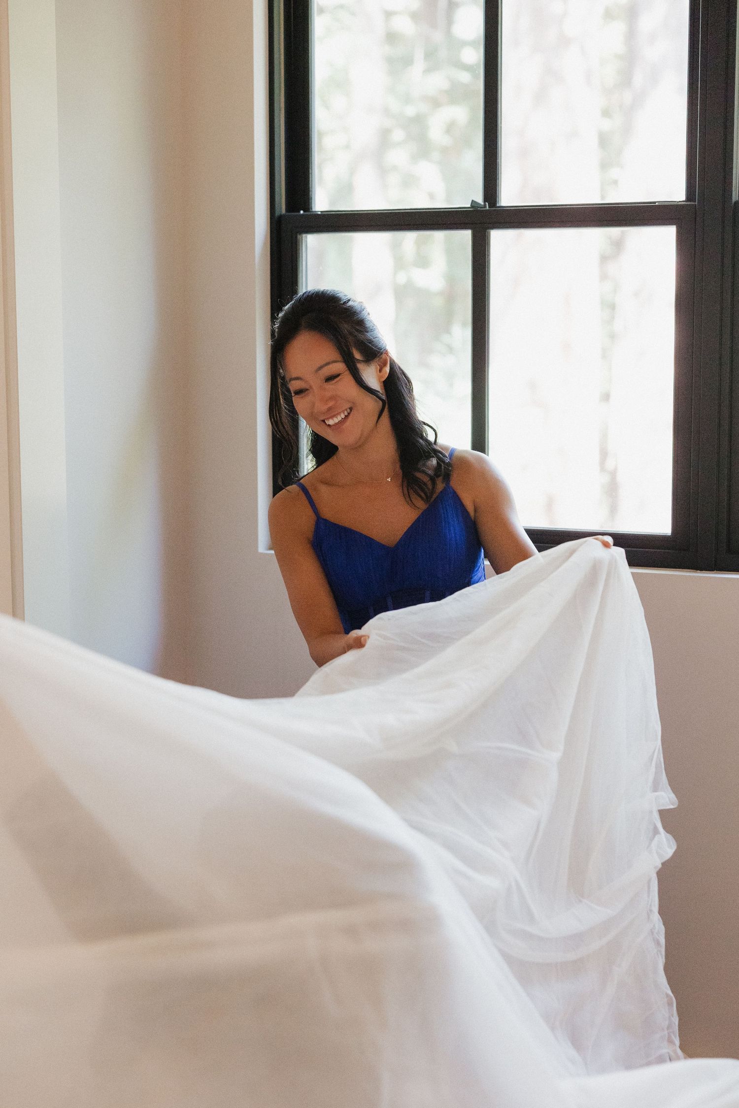 A sequence of photos showing flowing white fabric being gracefully tossed against a bright interior backdrop.