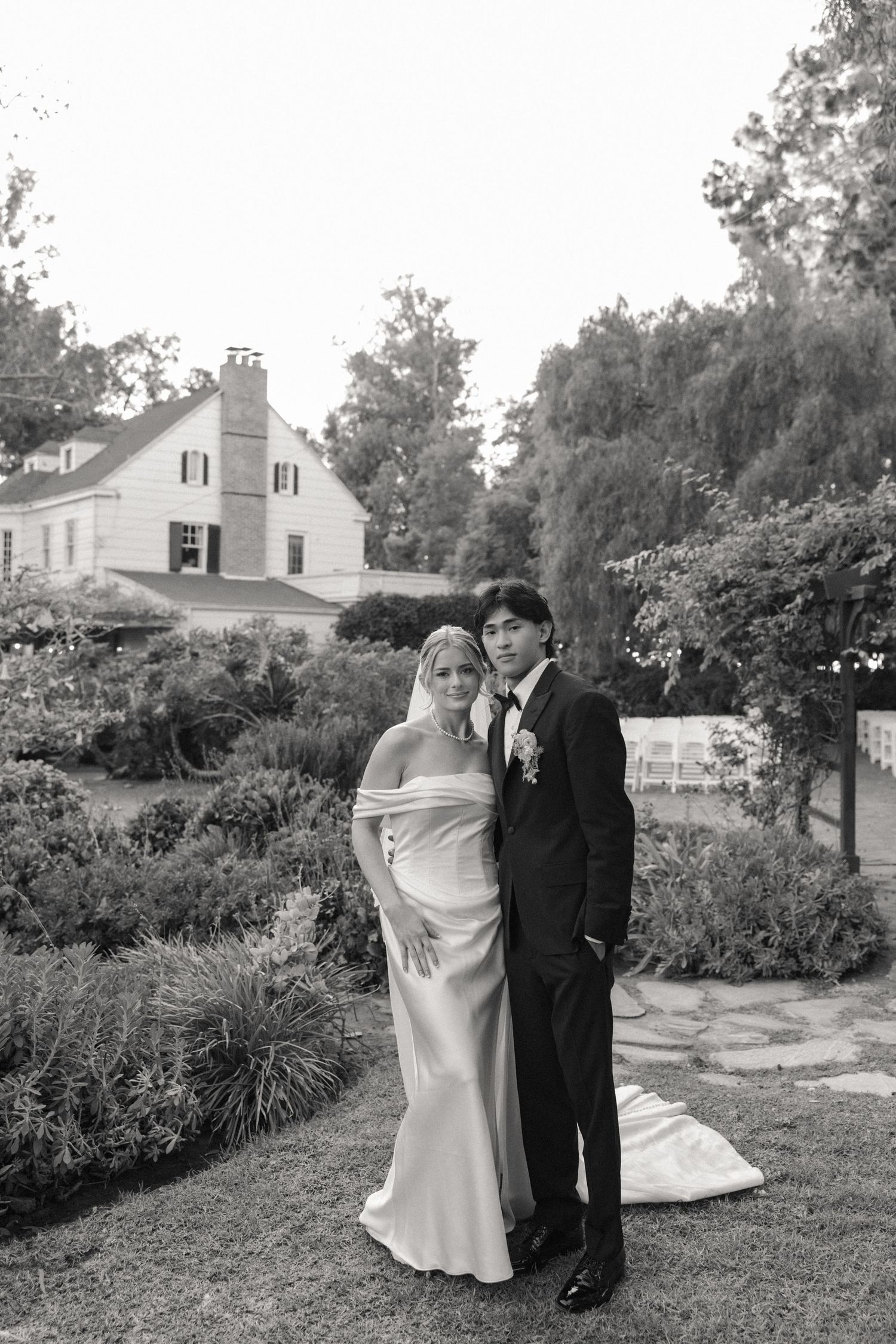 Black and white wedding portraits of a couple posing together in a garden setting.