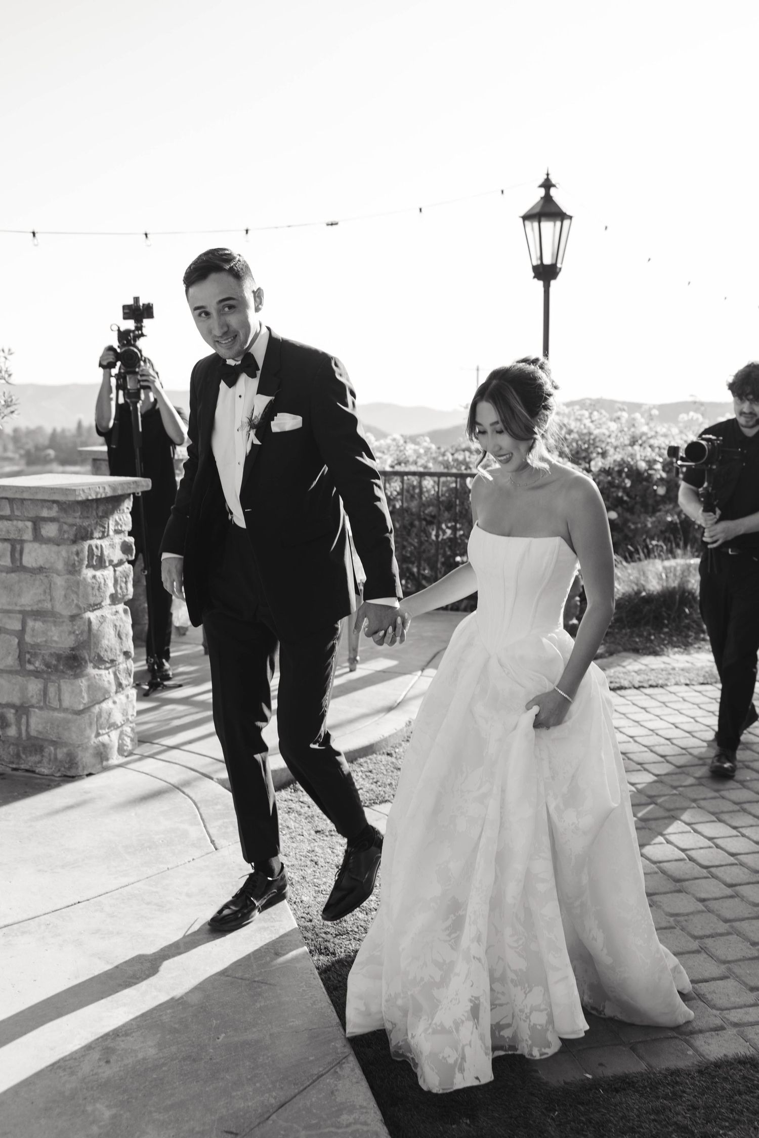 Multiple black and white photos capture a couple dipping and dancing together on a paved terrace at sunset.