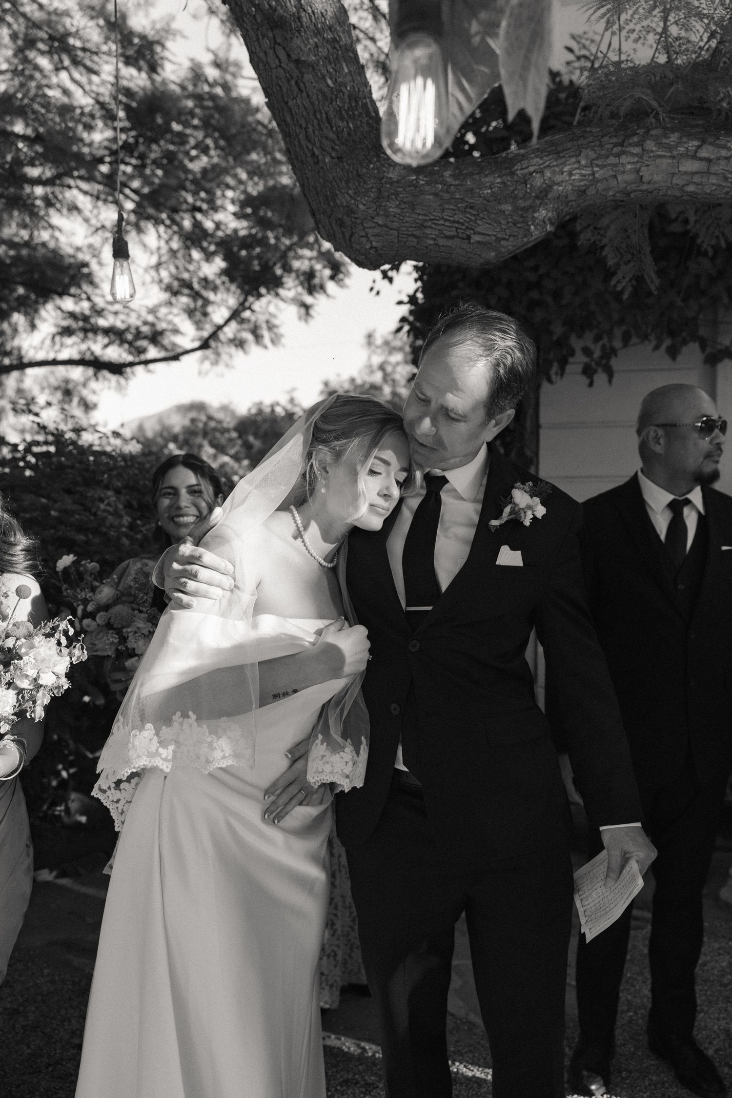 A series of black and white wedding photographs showing intimate moments between a couple during their ceremony.