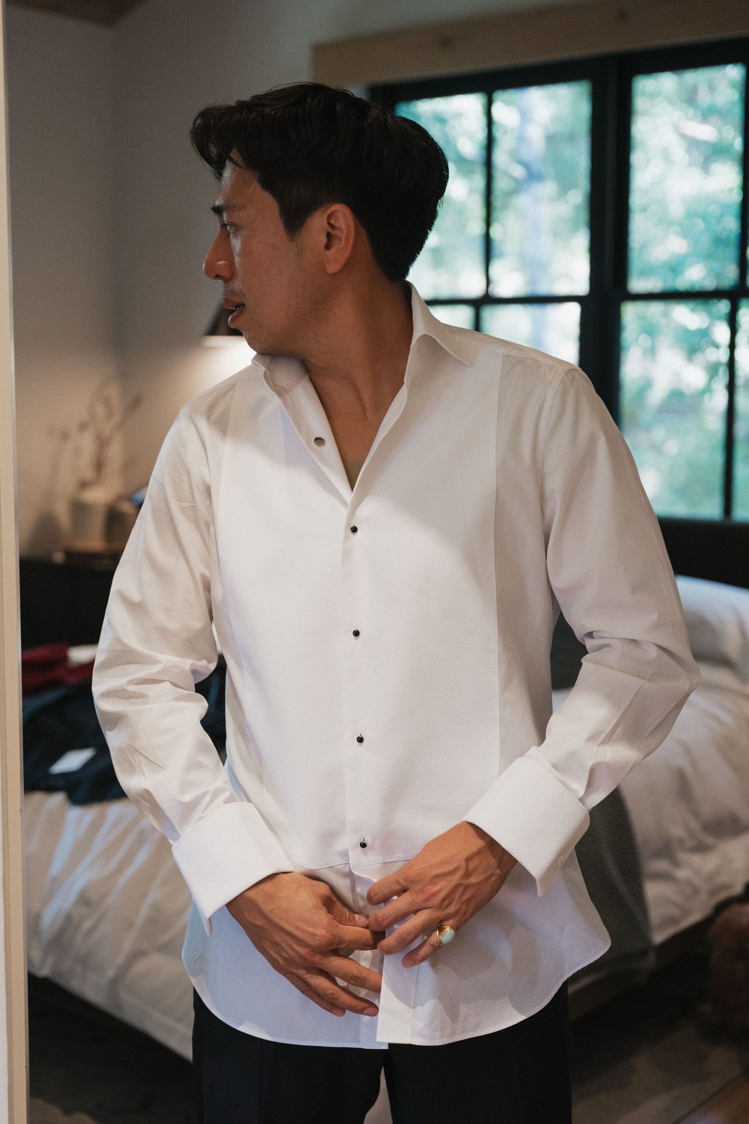 Close-up sequence showing details of a white dress shirt being buttoned during formal preparation.