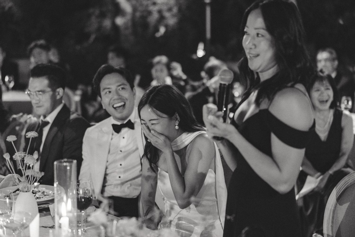 Candid black and white shots of wedding guests laughing and celebrating during the reception.