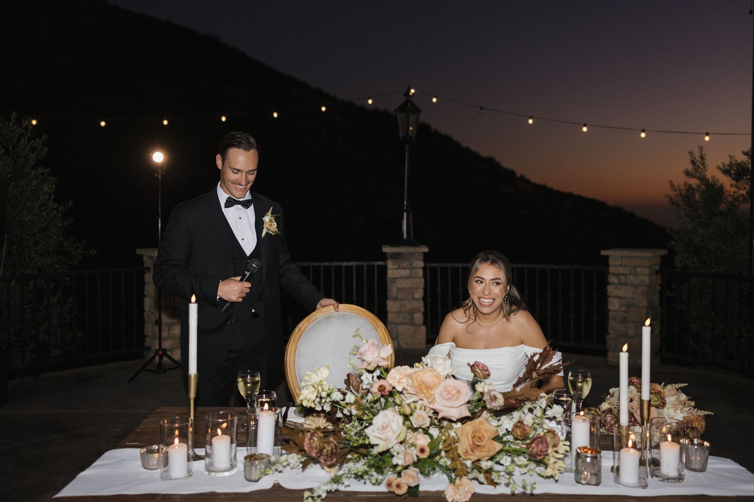 Evening wedding reception setup with elegant table decorations and ambient lighting.