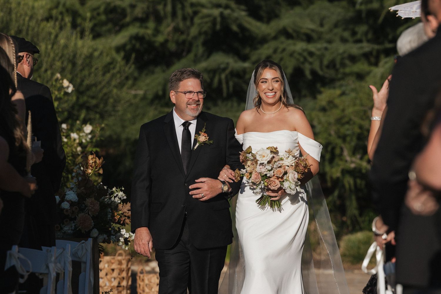 Wedding party celebrating outdoors with joyful reactions during a sunset ceremony.