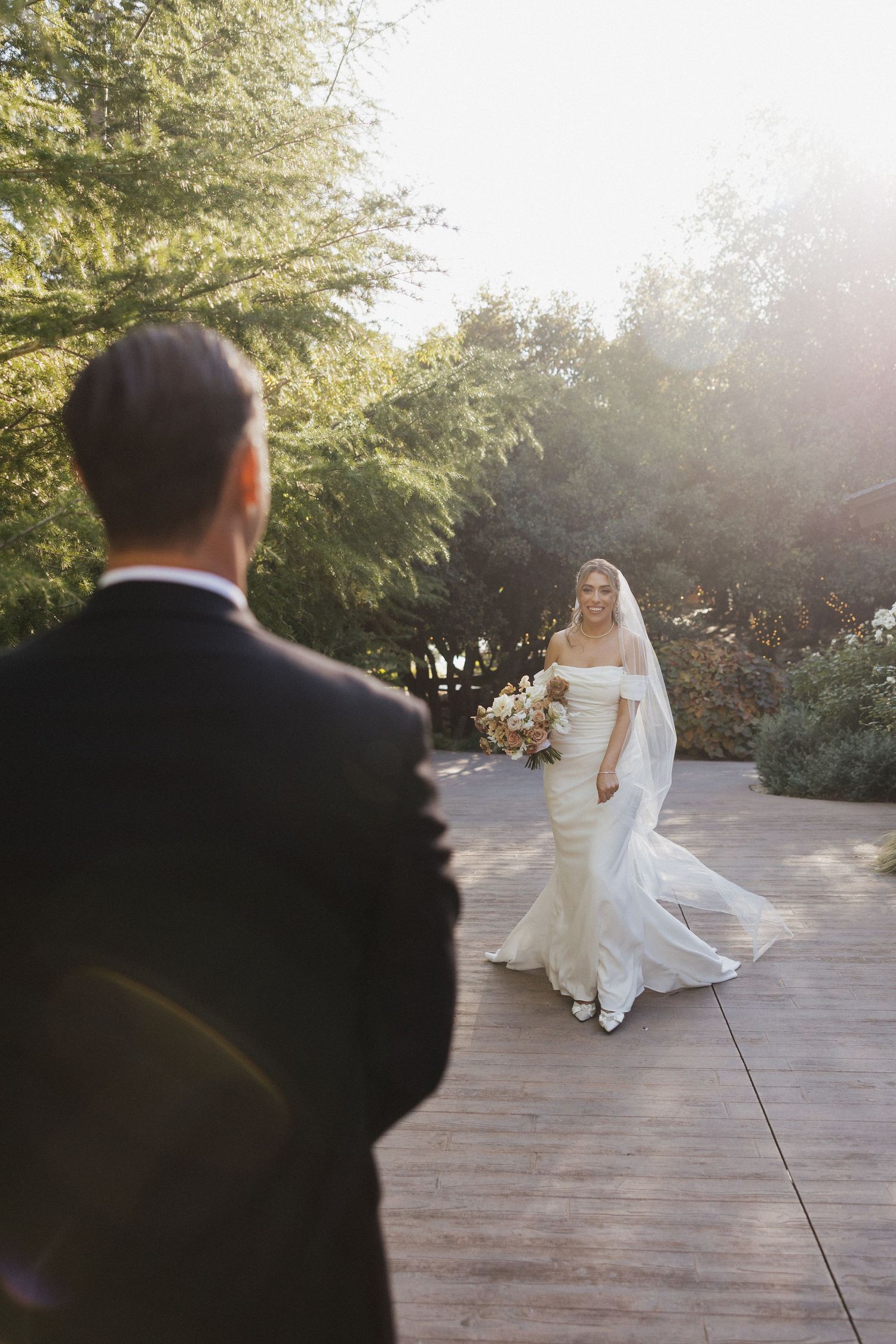 A flowing white wedding dress twirls on a stone patio during a sunset photoshoot.