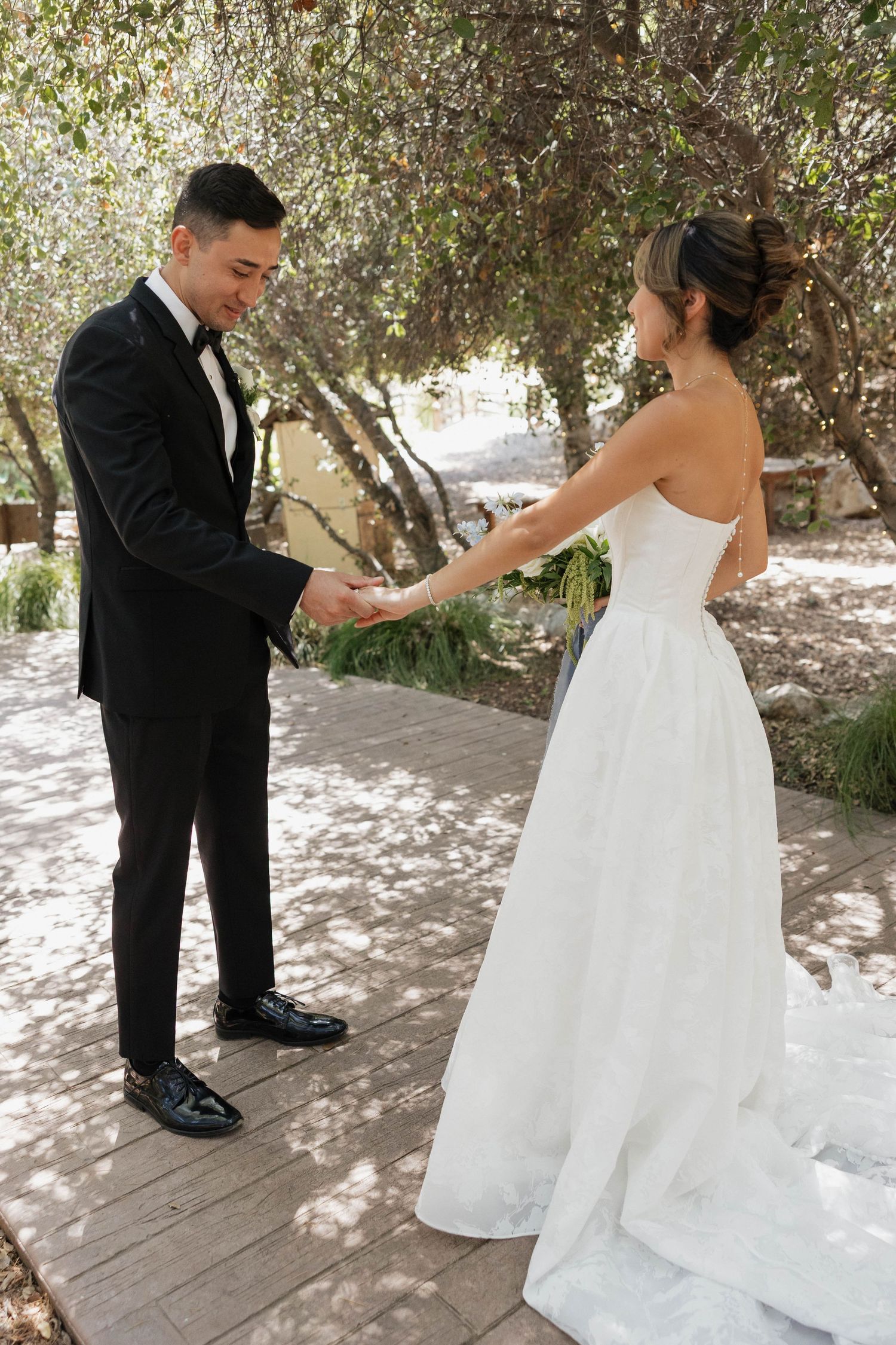 Wedding ceremony first look moment on a shaded outdoor deck.