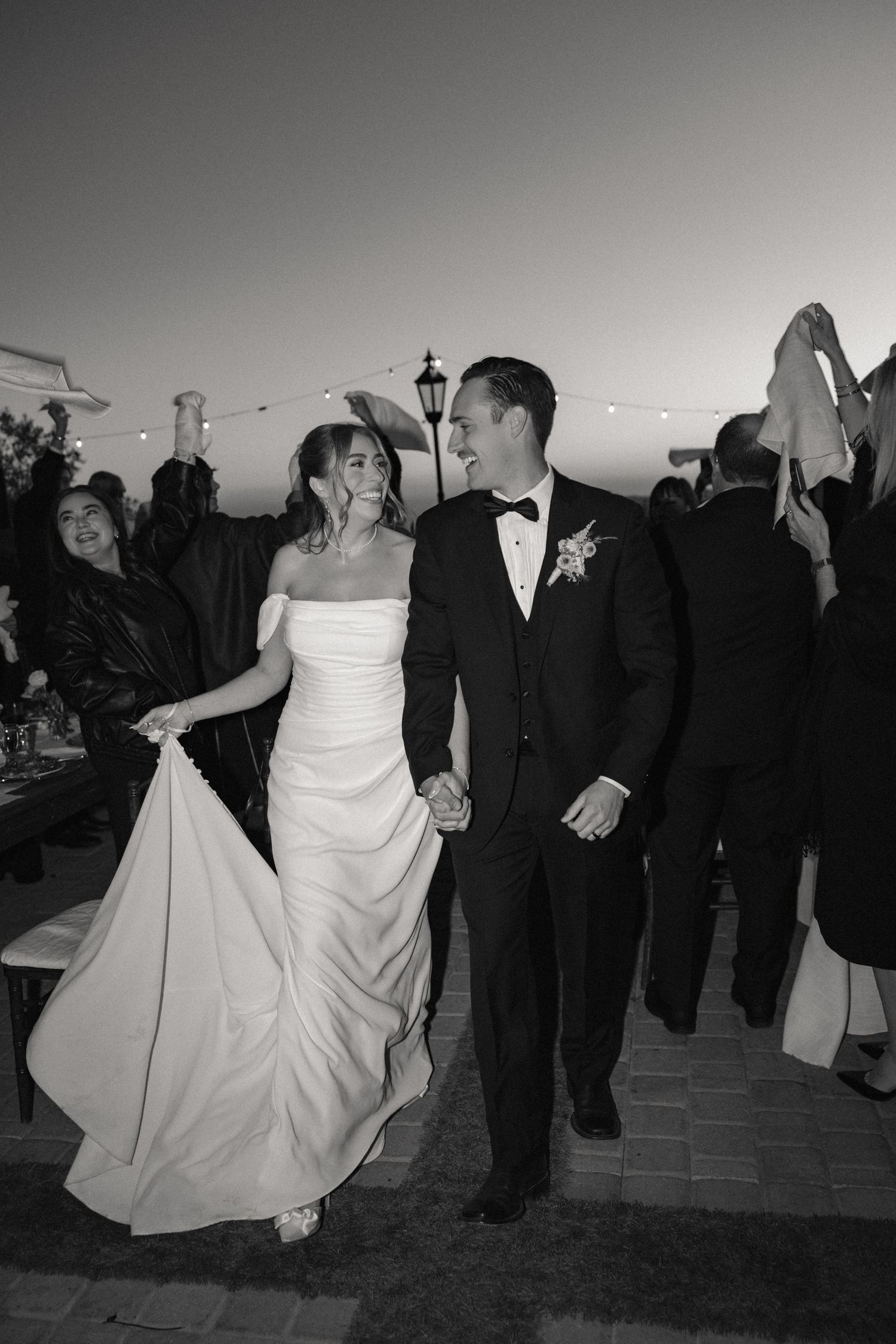 Black and white photo of wedding celebration with dancing on outdoor patio.