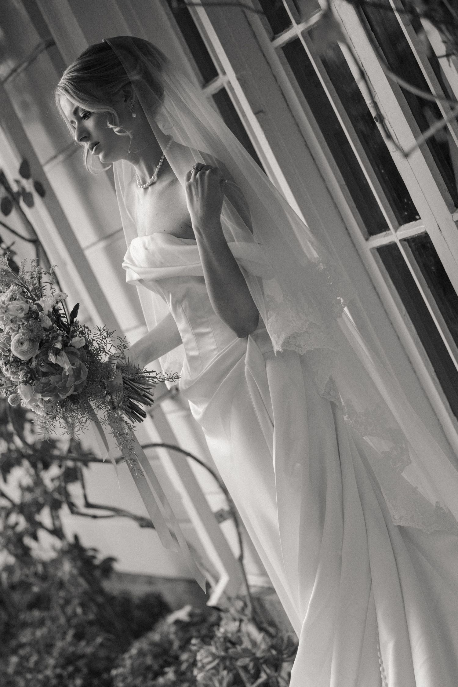 Elegant white wedding dresses photographed against classic white colonial architecture.