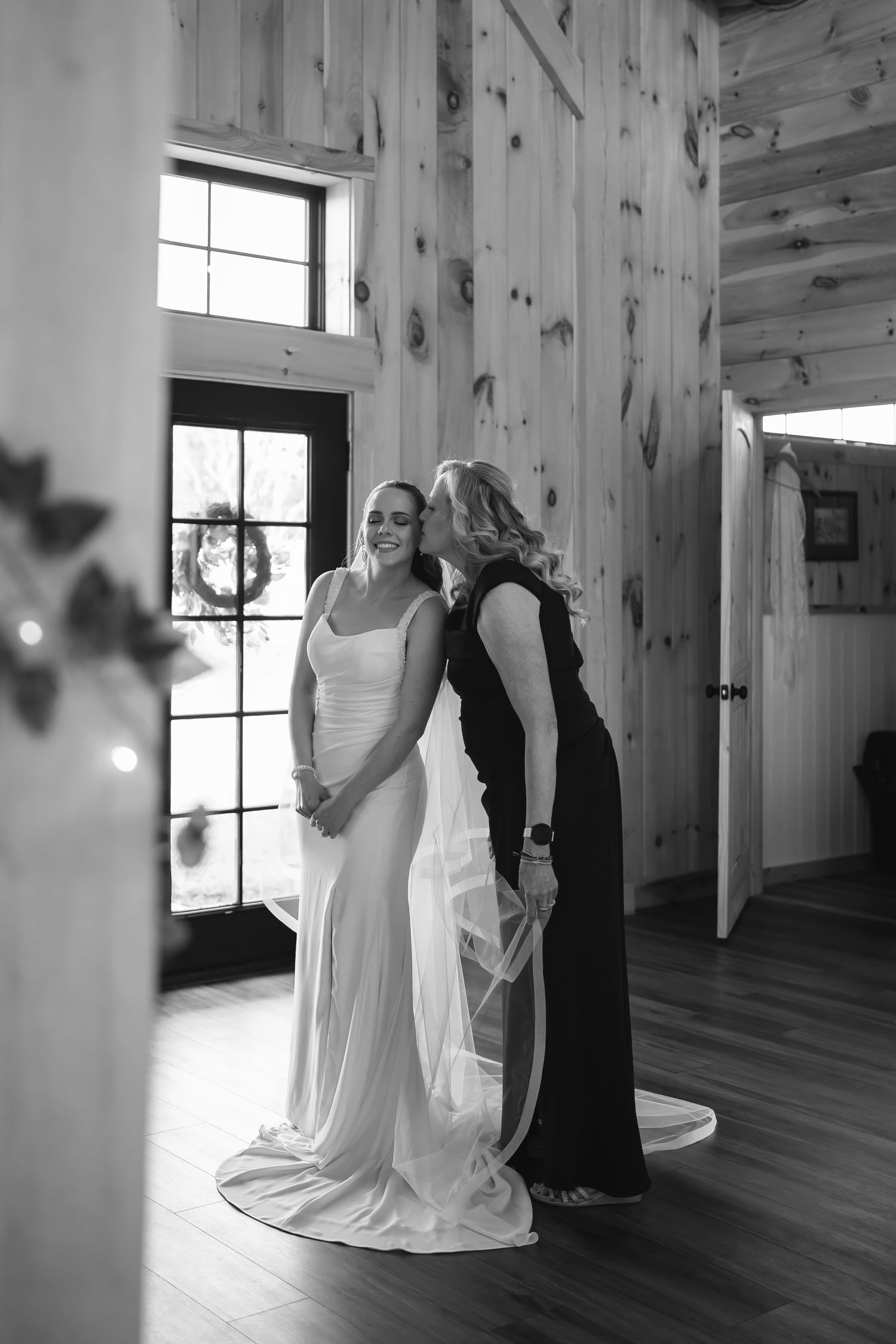 Black-and-white bridal dresses hanging in rustic room with window light | wedding details photography in Northern Virginia.