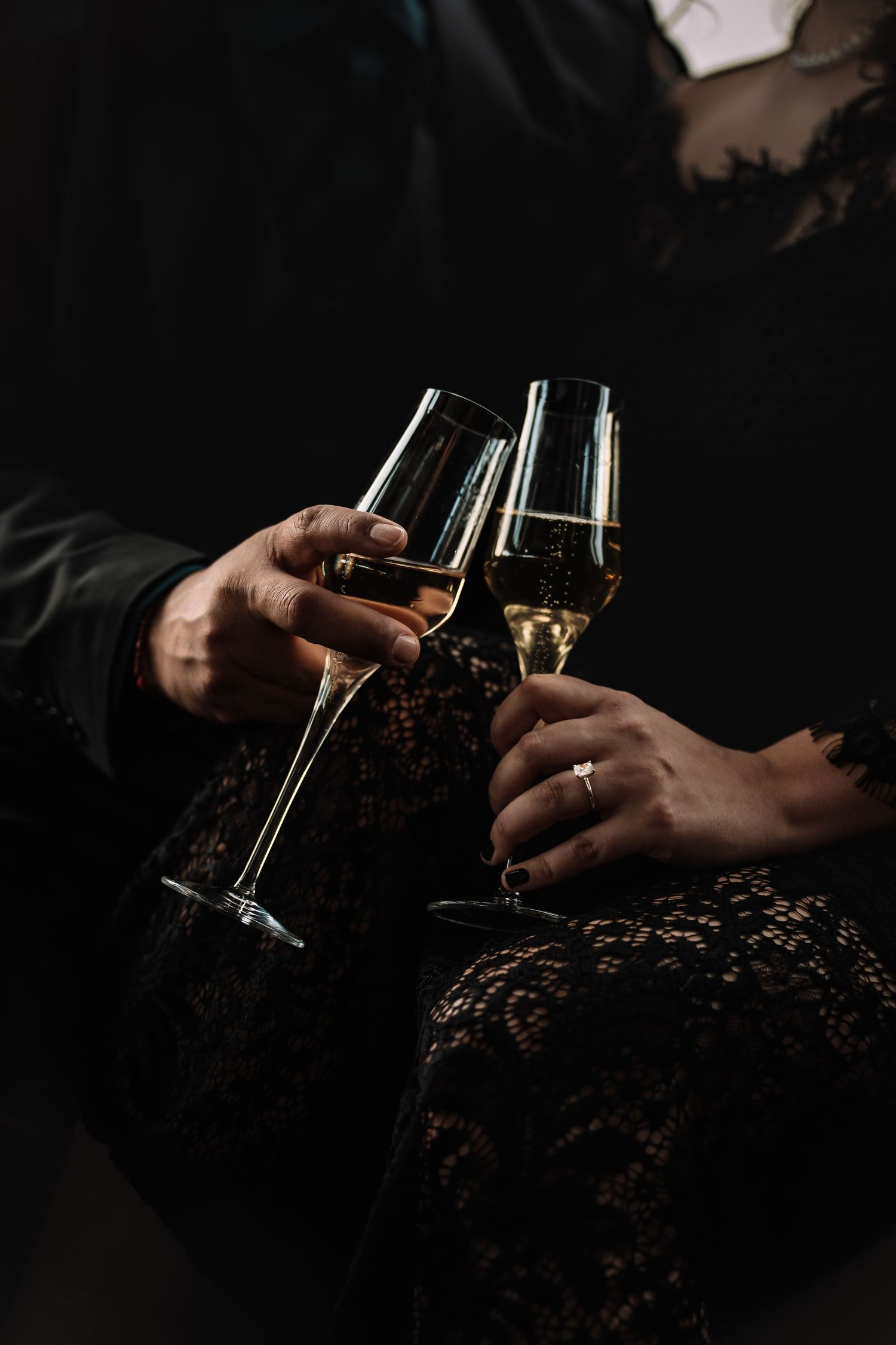 Champagne clink close-up against black lace | wedding celebration detail photo in Baltimore, Maryland.