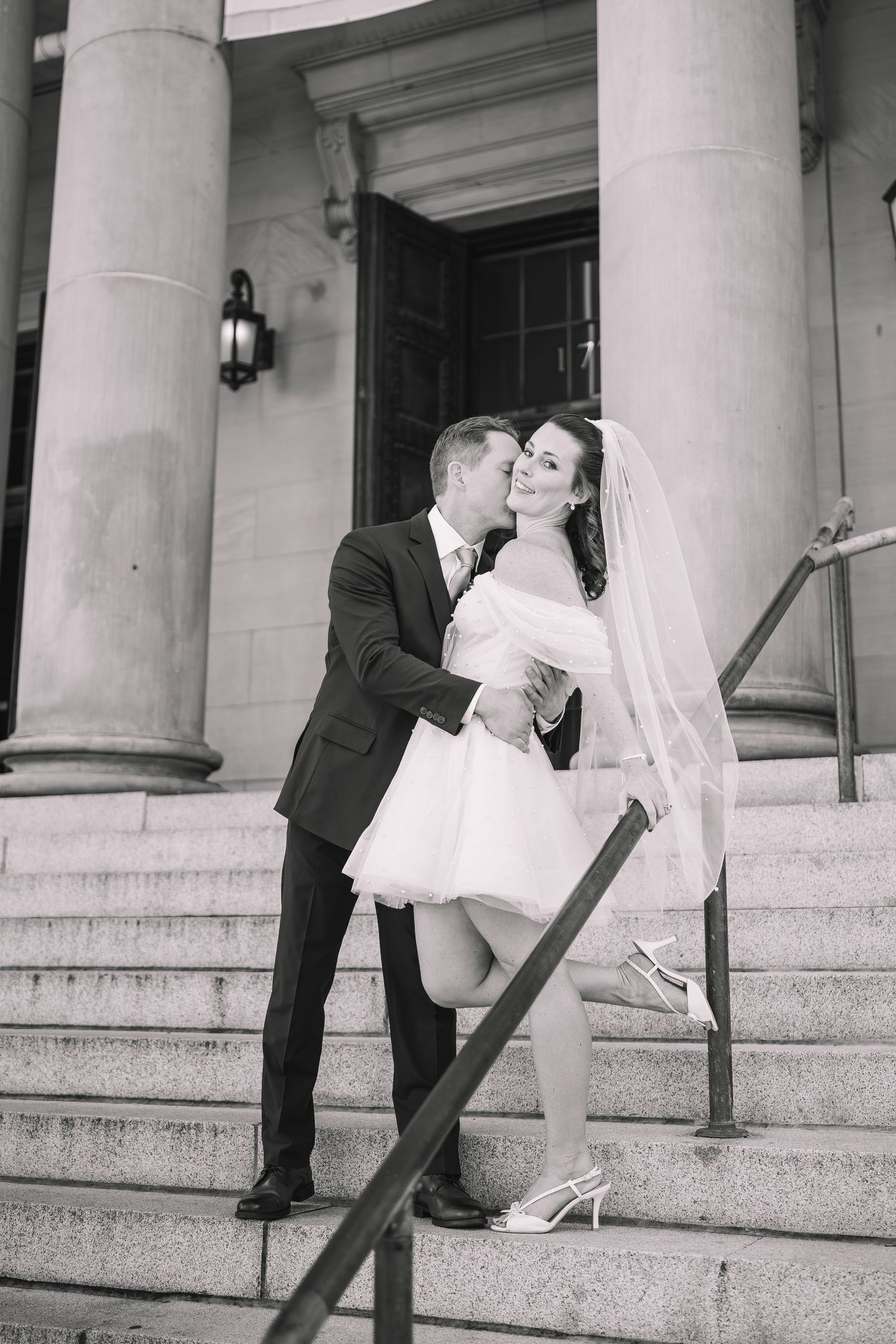 Black and white photo series of couple posing romantically on classic building steps.
