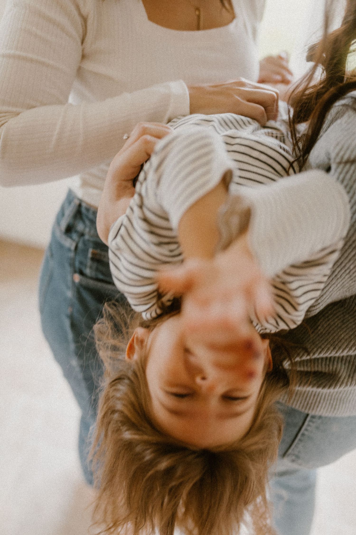 A playful moment captured in soft lighting shows laughter and connection during playtime.