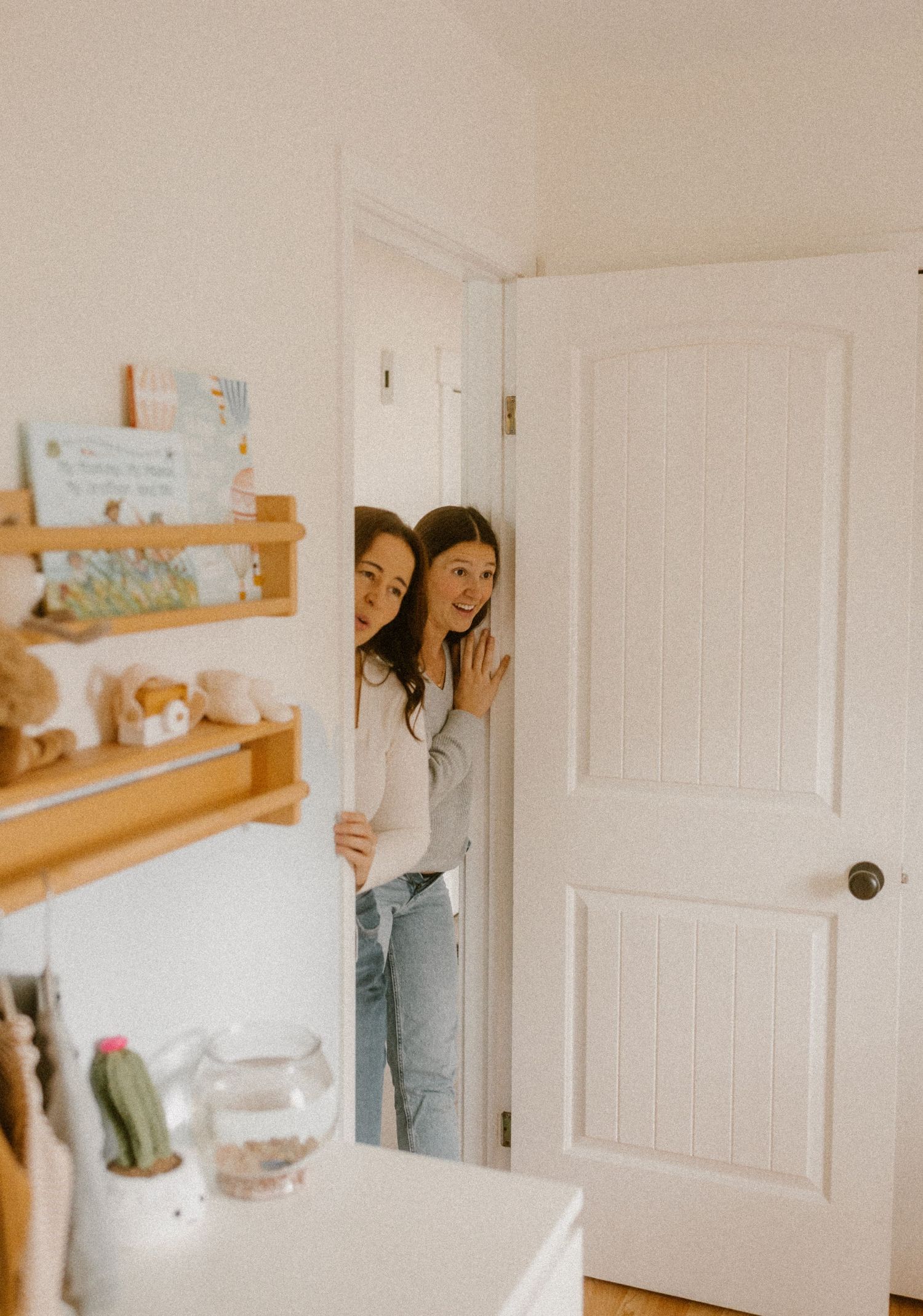 Playful peek through a white doorway in a bright home interior.