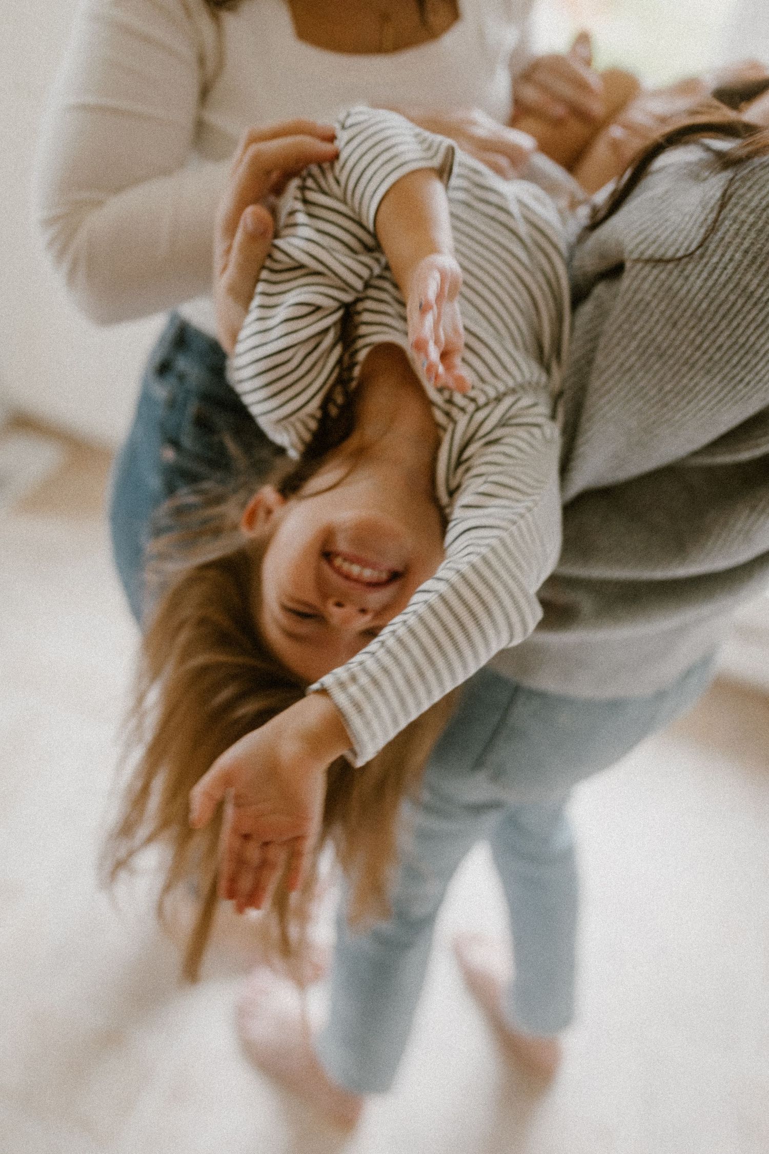 Candid moment of playful interaction while wearing striped clothing in a bright interior.