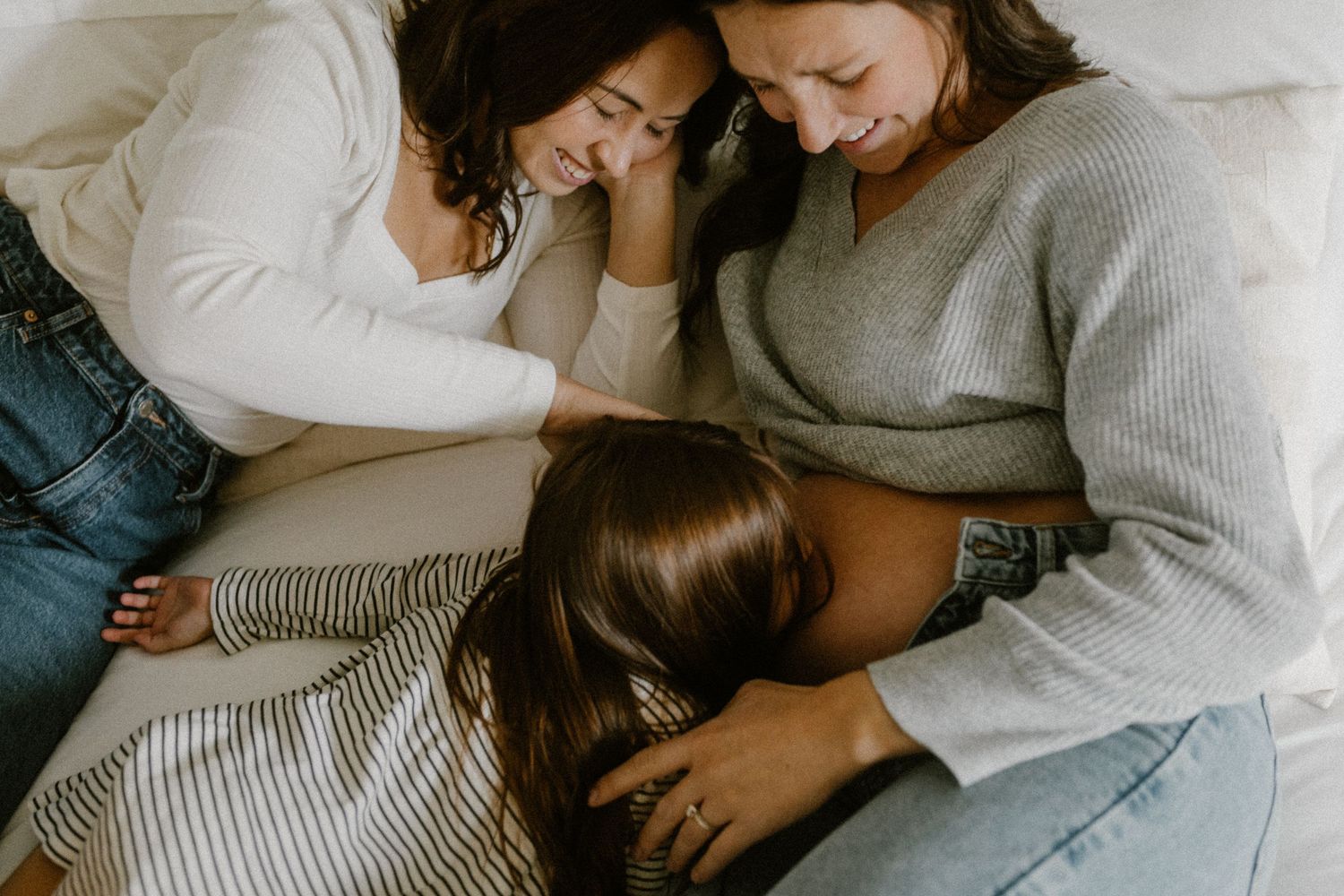 An intimate moment of connection and laughter shared on a comfortable bed.