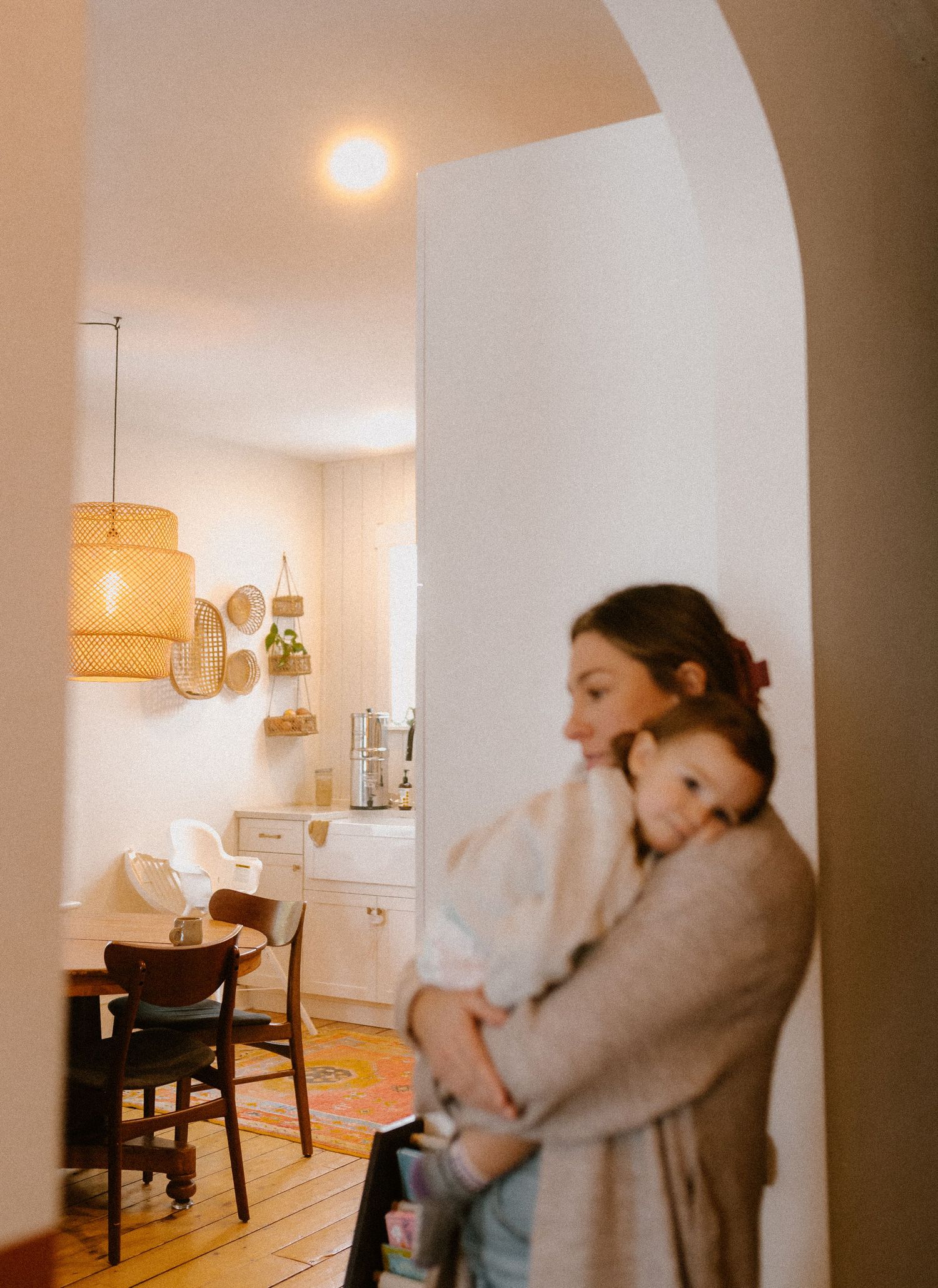 A cozy moment viewed through an archway in a warmly lit home interior.