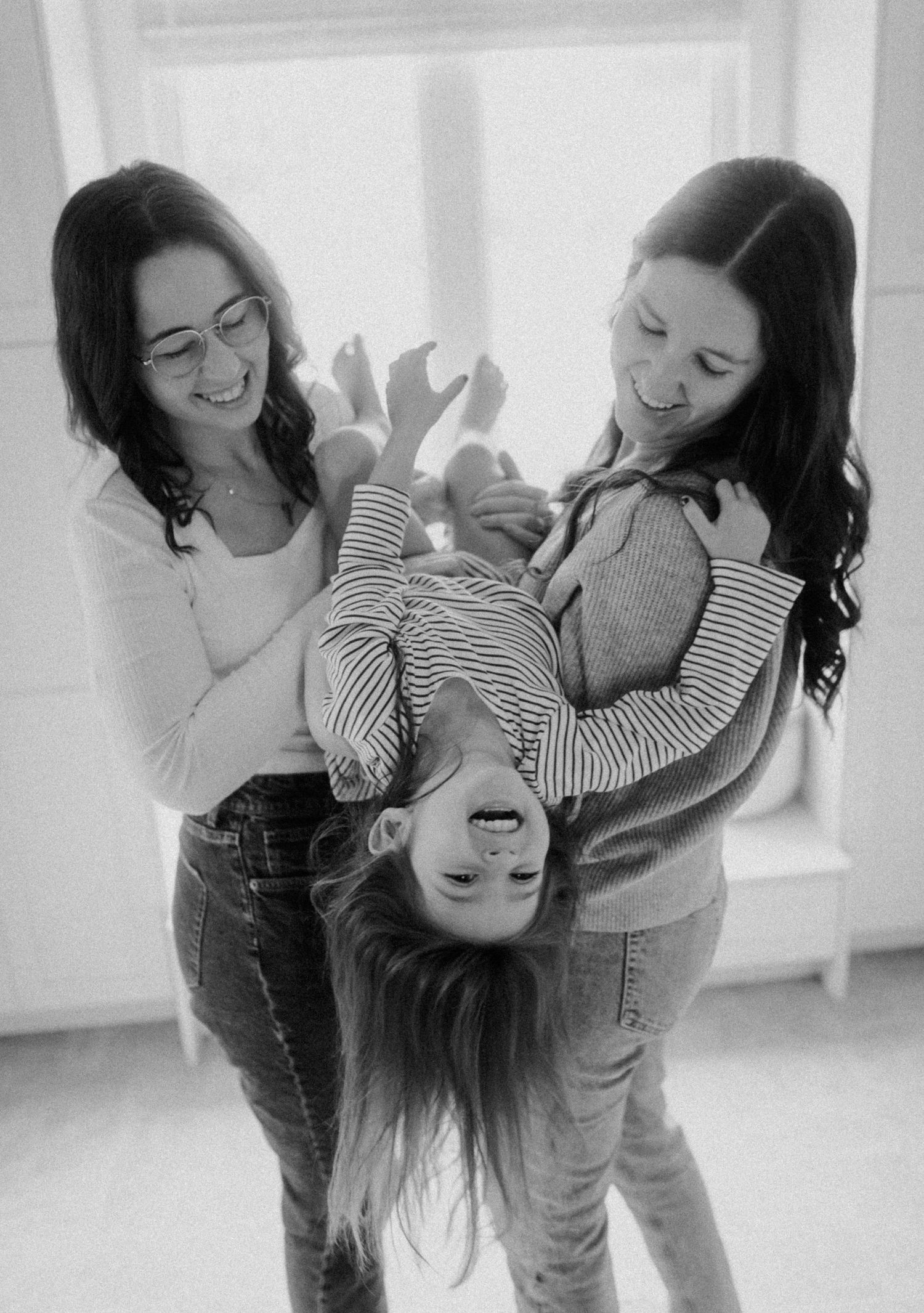 Monochrome photo showing a playful upside-down moment filled with joy and laughter.