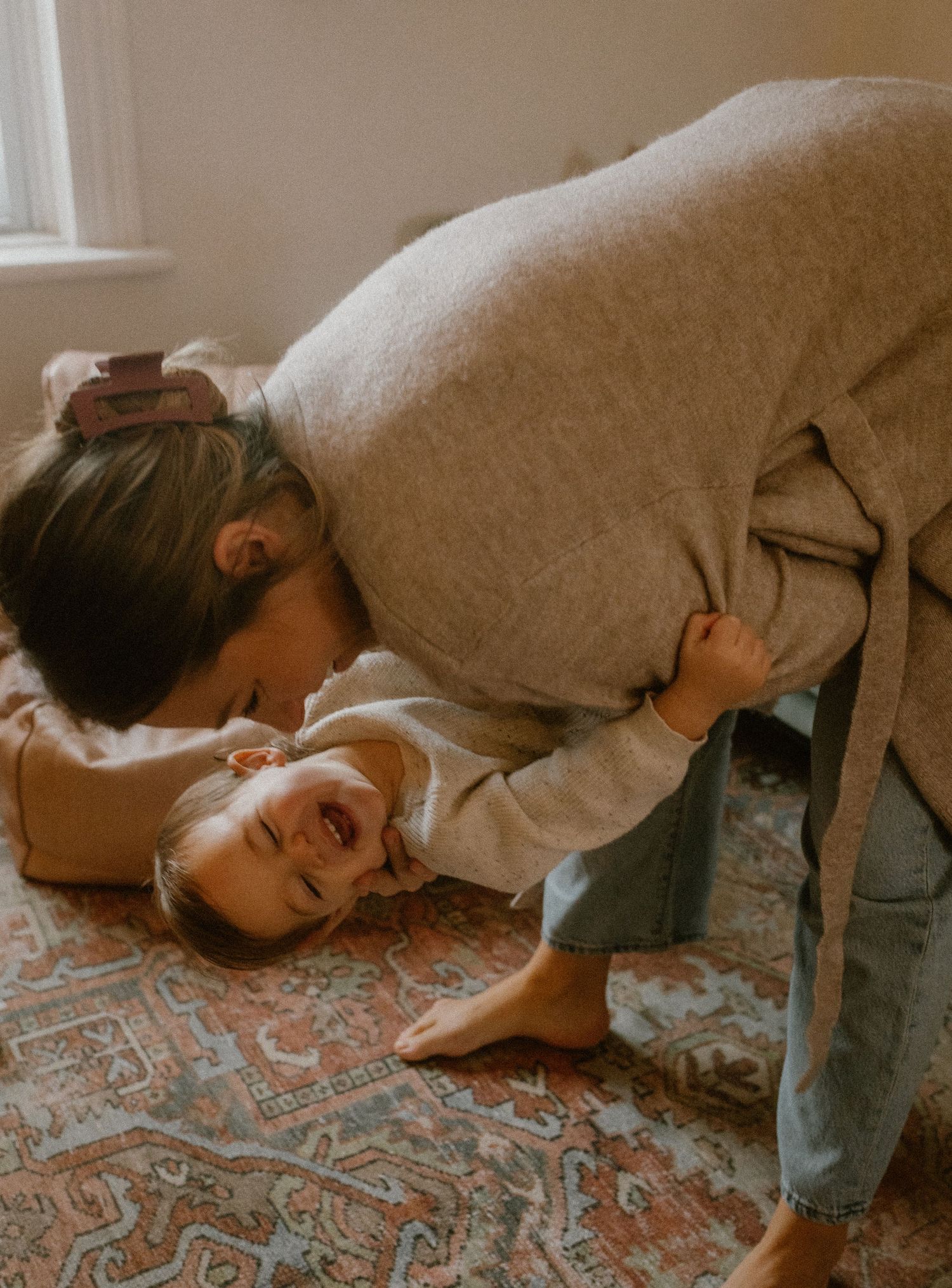 Playful moment captured on a patterned carpet in warm, vintage tones.