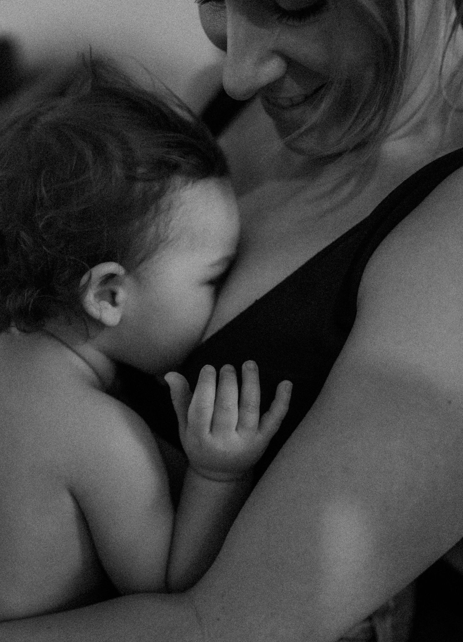 Tender black and white portrait capturing an intimate motherhood moment.
