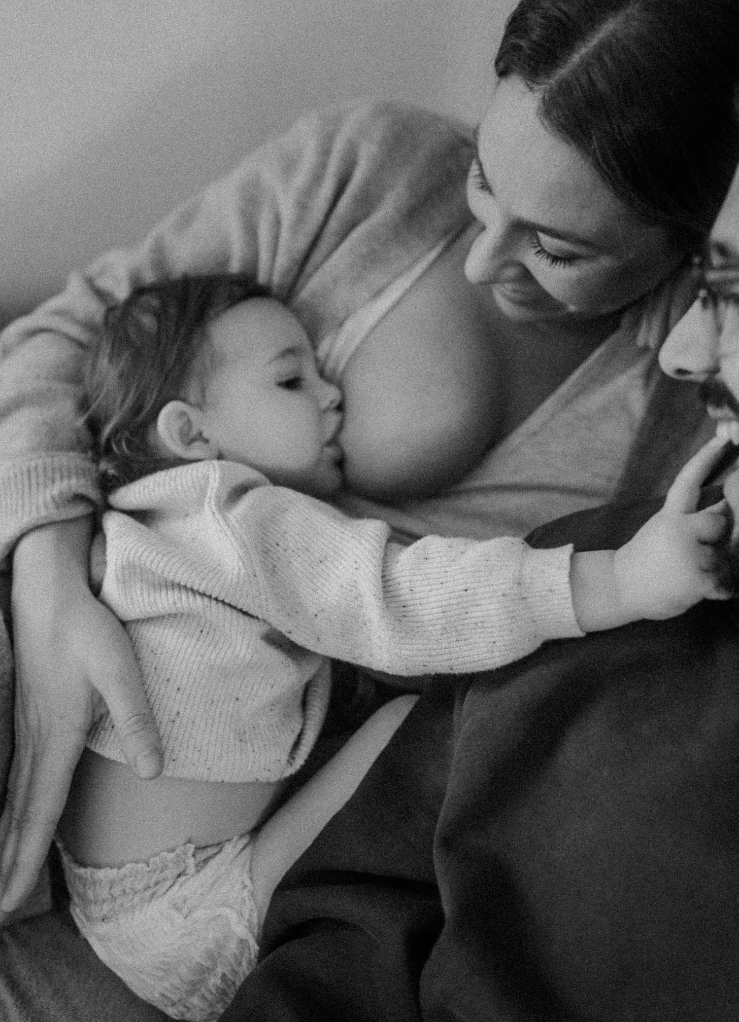 Intimate black and white portrait showing tender family moment on a couch.
