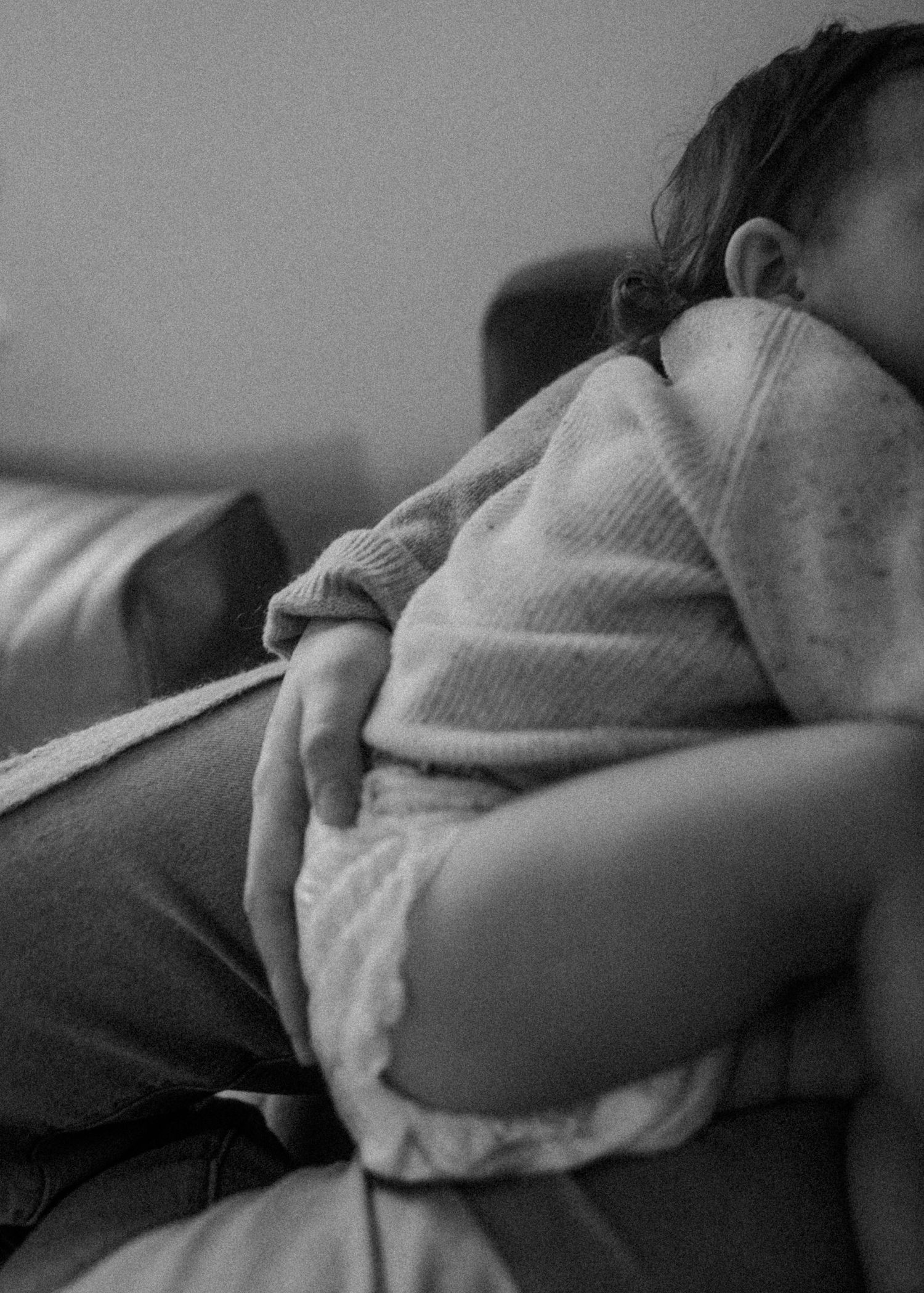 A tender close-up shot of a baby sleeping in cozy sweater clothing.