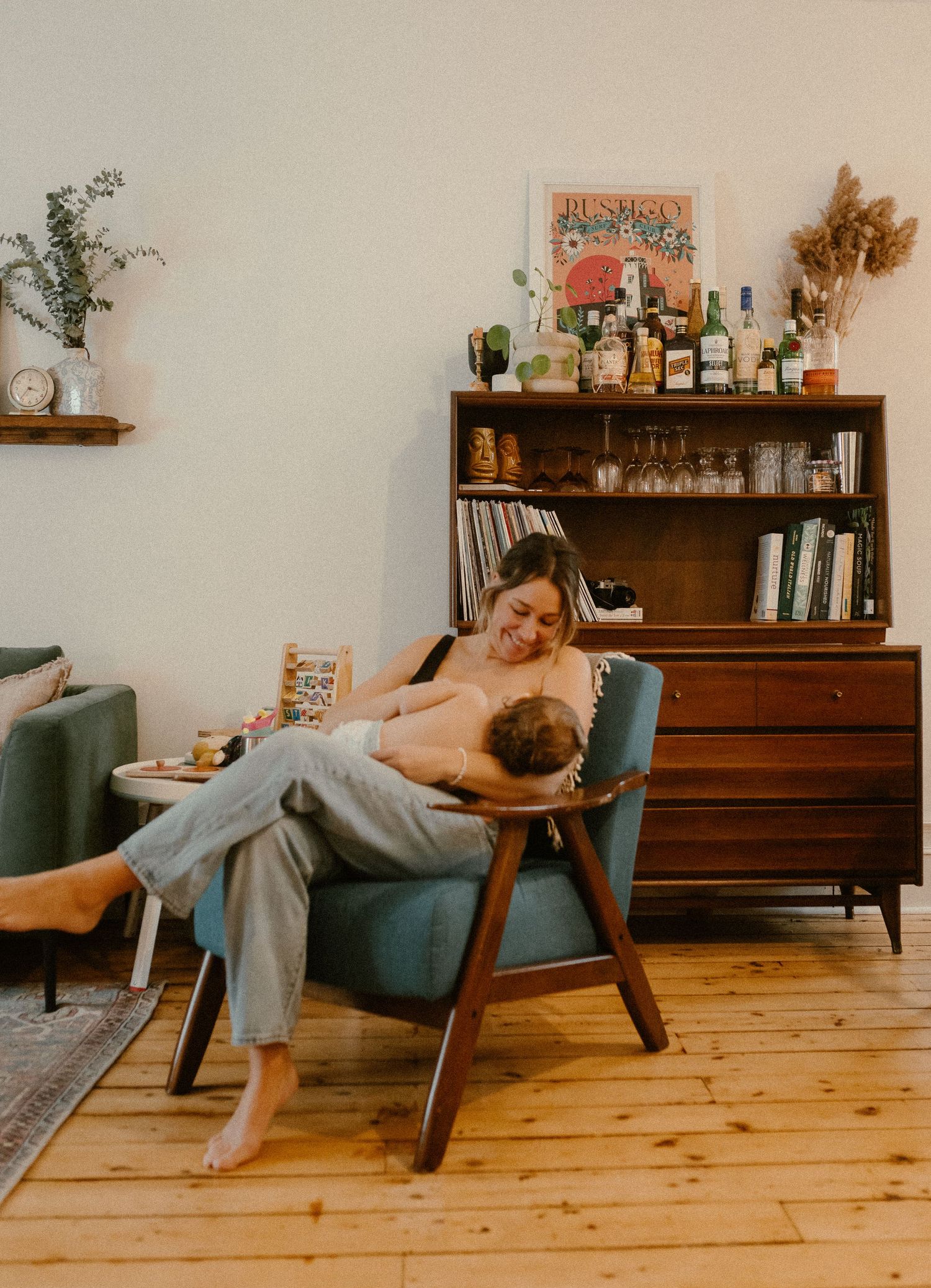 Quiet moment in living room with mid-century furniture and bar cart in background.