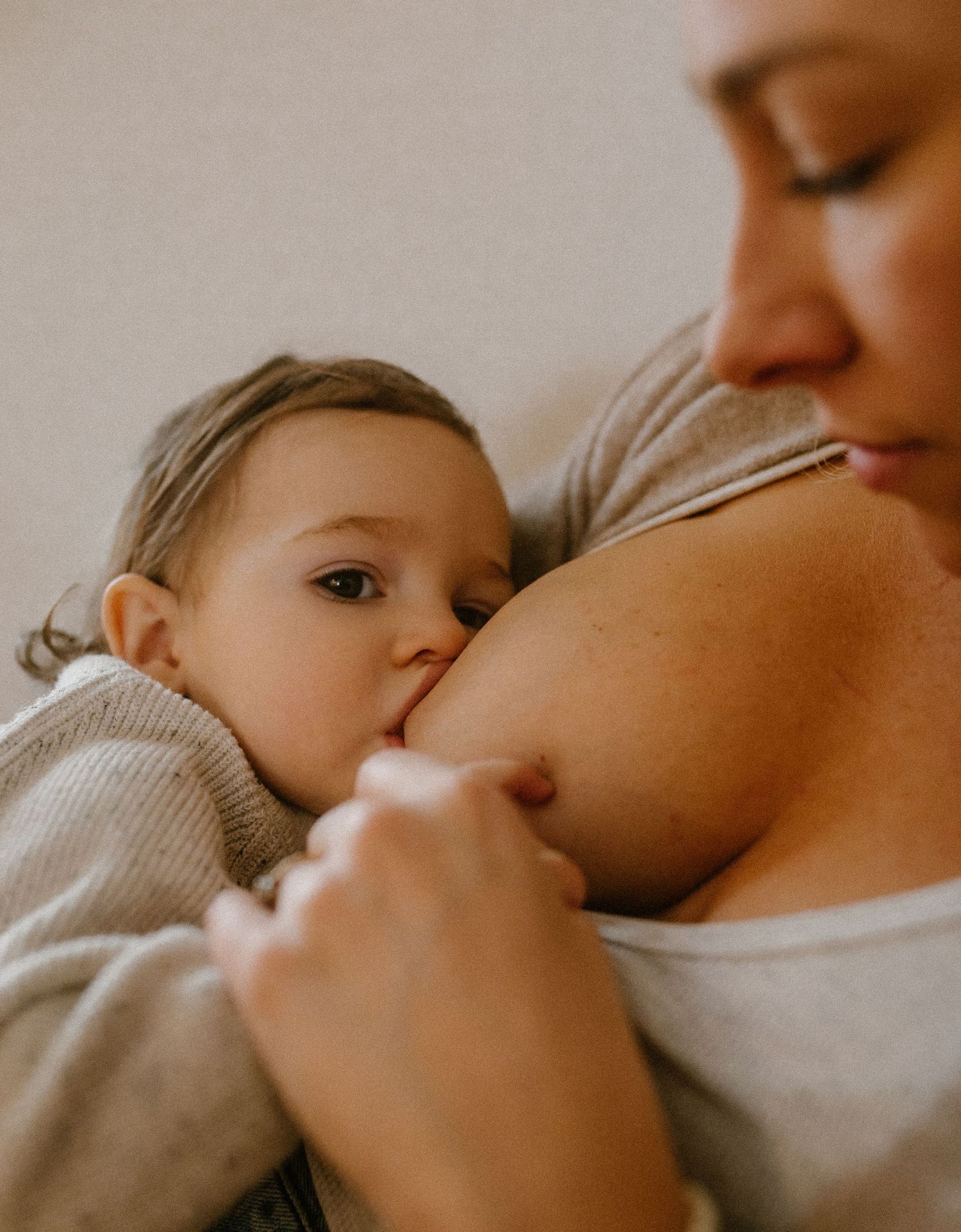 An intimate nursing moment captured in warm, natural lighting.