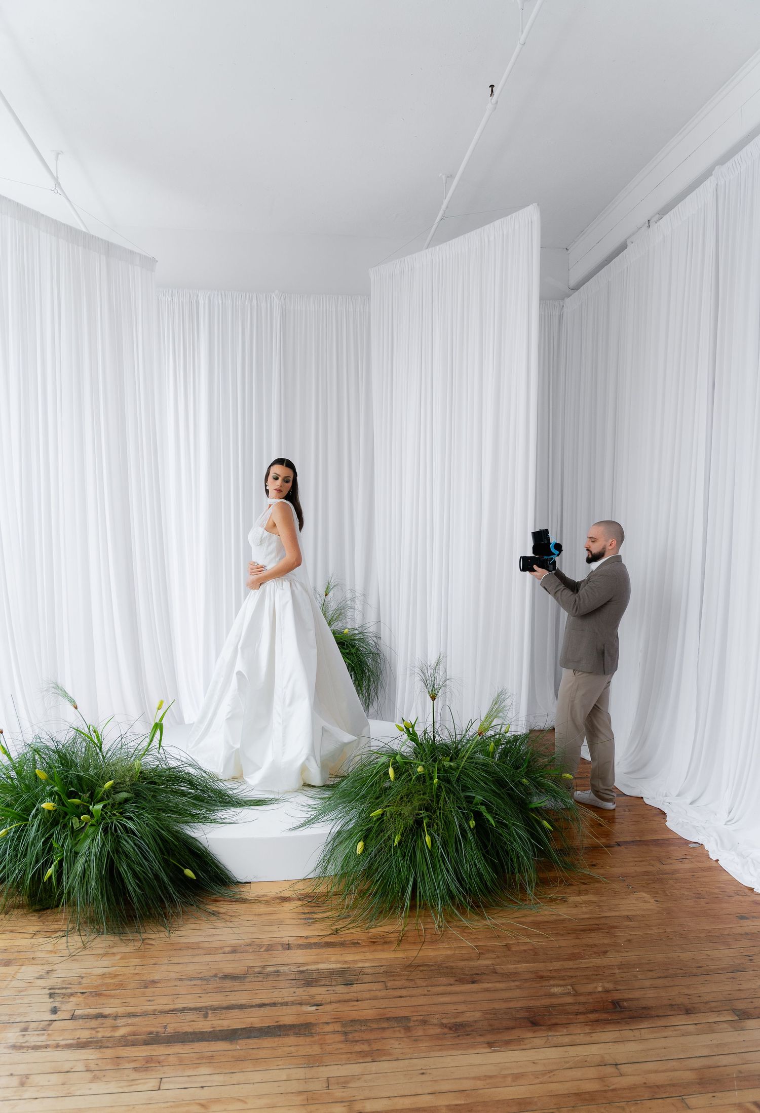 A sequence of four artistic photos showing movement and dance against white curtains and potted plants on wooden flooring.
